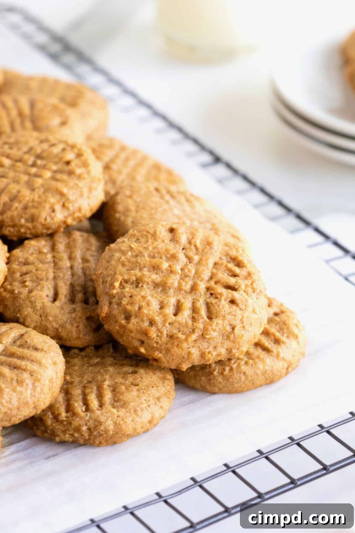 Wholesome Peanut Butter Quinoa Cookies 9 A generous pile of freshly baked peanut butter quinoa cookies resting on a parchment-lined cooling rack, emphasizing their wholesome appeal and inviting texture.