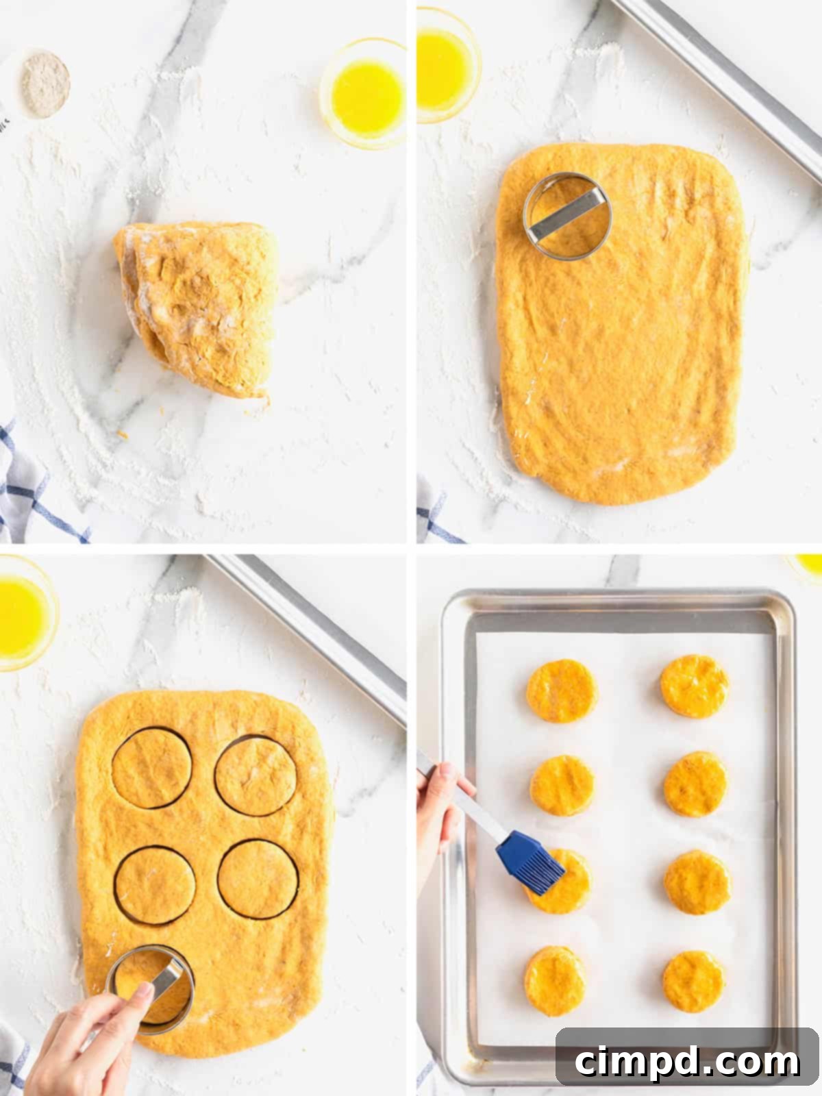 Image showing cut pumpkin biscuit dough arranged on a parchment-lined baking sheet, brushed with melted butter.
