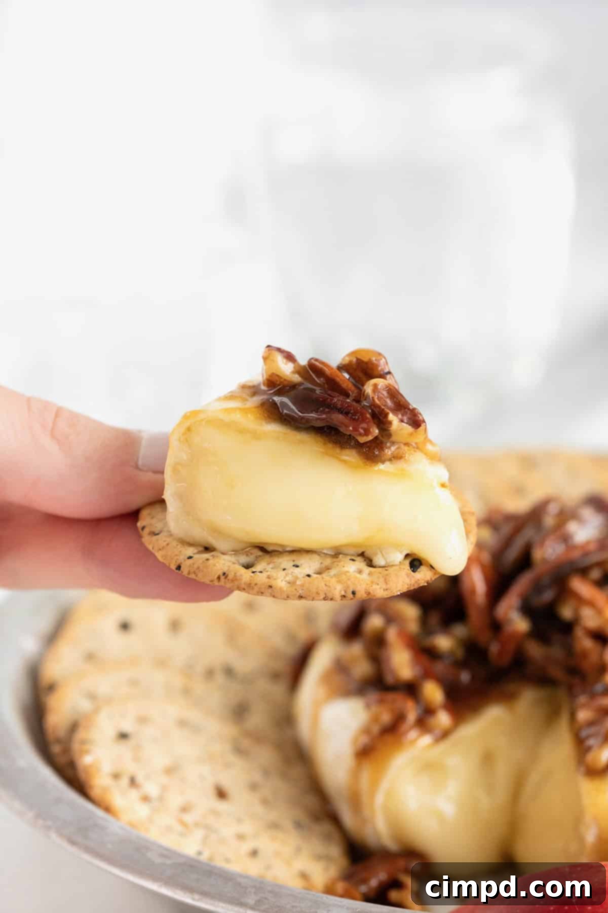Caramel Pecan Baked Brie 3 A bite of Pecan Pie Baked Brie on a round multigrain cracker.