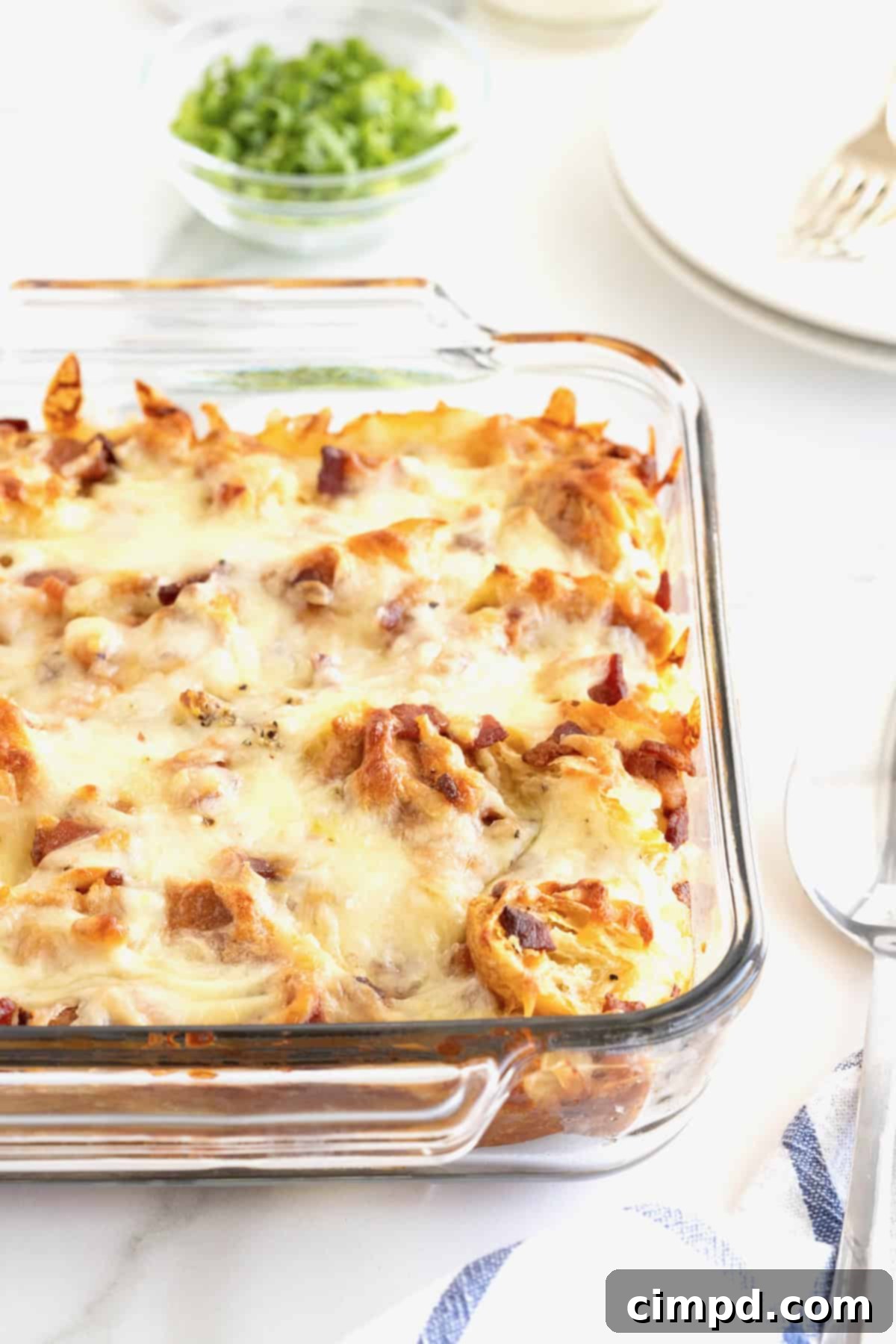 Golden Croissant Breakfast Bake 8 A glass baking dish of golden-brown croissant breakfast casserole, perfectly cooked and ready to be served.