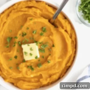 A beautifully presented serving bowl of mashed butternut squash, topped with butter and fresh parsley, perfect for holiday gatherings.