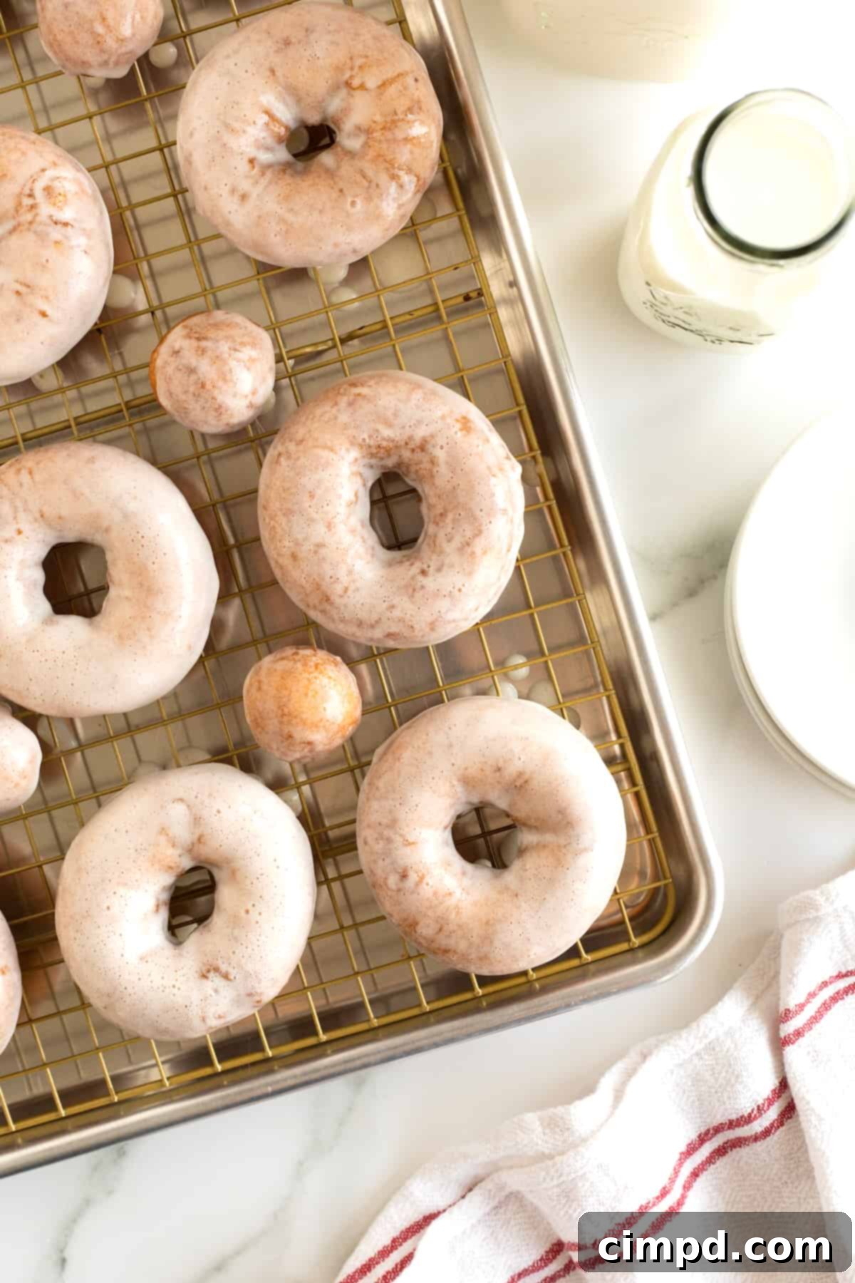 Four glazed donuts and two donut holes on a wire cooling rack.