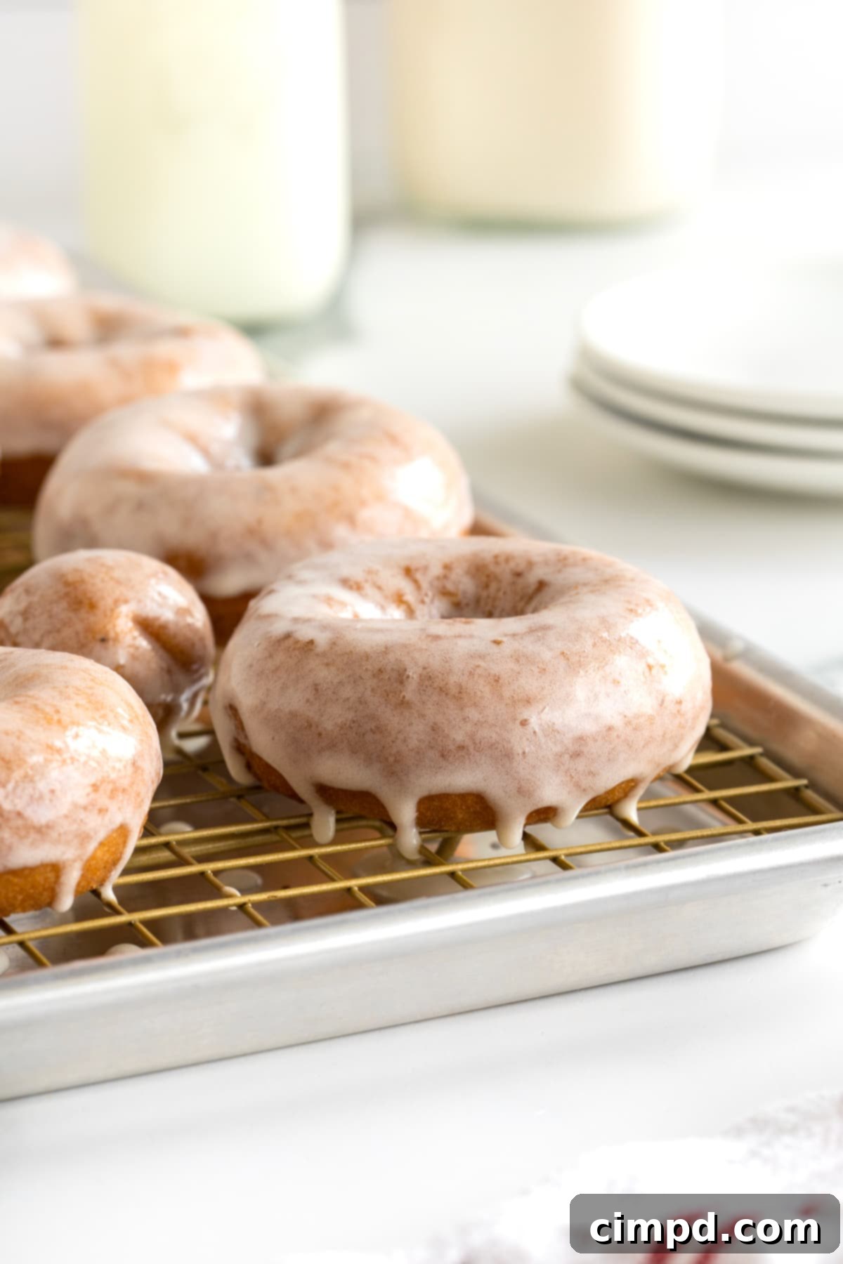 Four glazed donuts and two donut holes on a wire cooling rack.