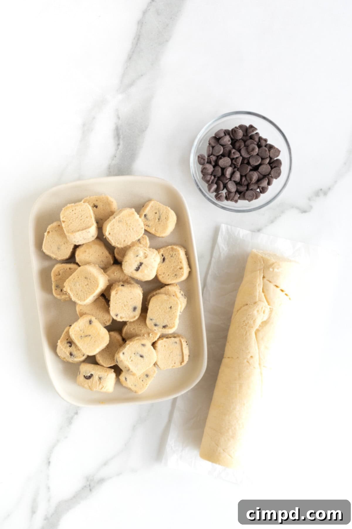 Ingredients to make Chocolate Chip Cookie Dough Cruffins on a white marble counter.