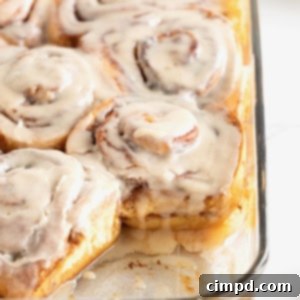 Store bought cinnamon rolls in a glass baking dish topped with icing.