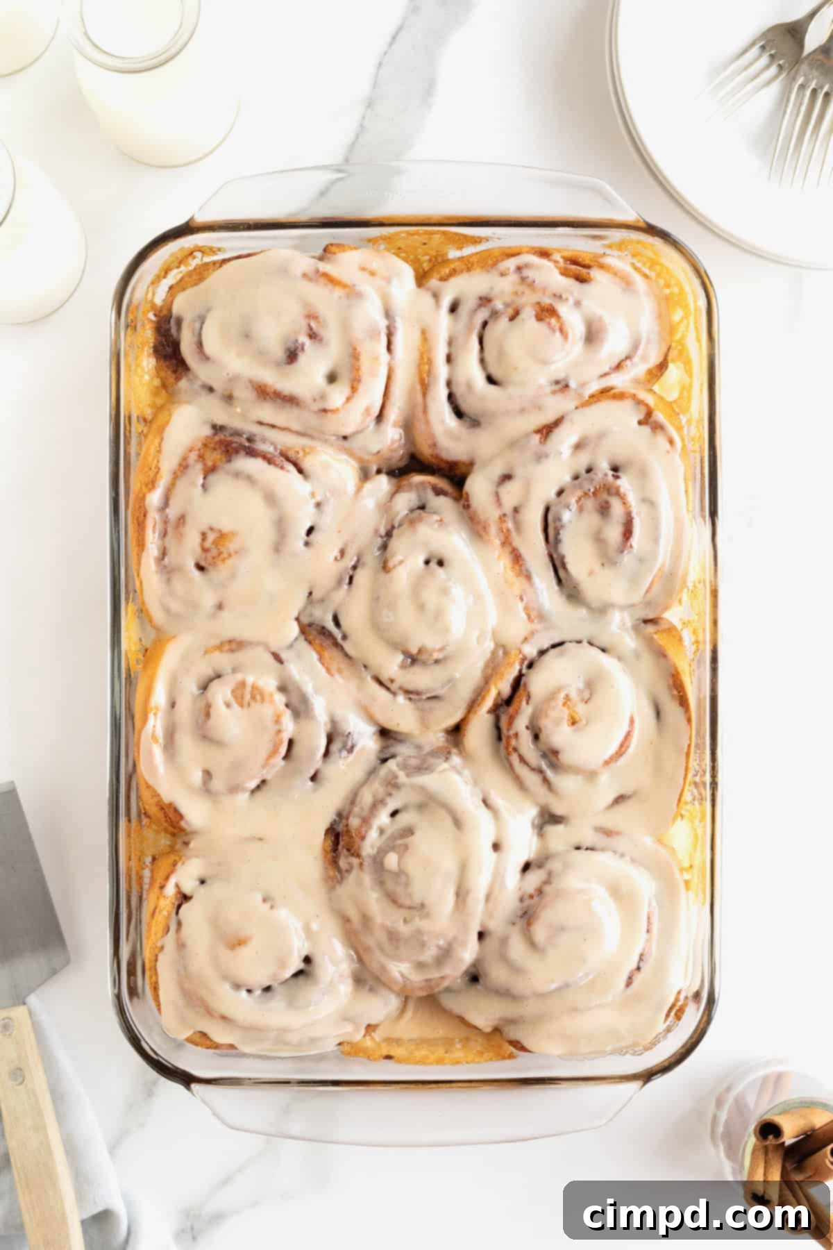 Store bought cinnamon rolls in a glass baking dish topped with icing.