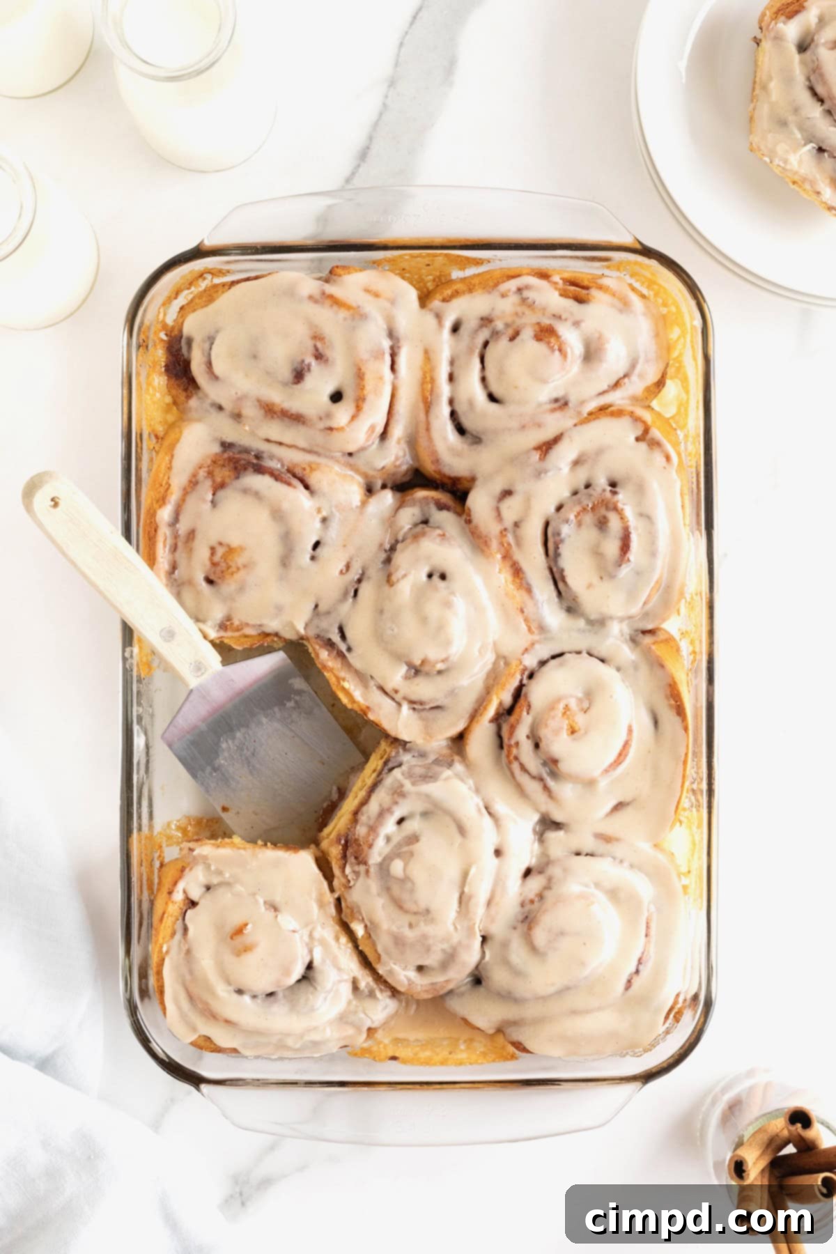 Store bought cinnamon rolls in a glass baking dish topped with icing.