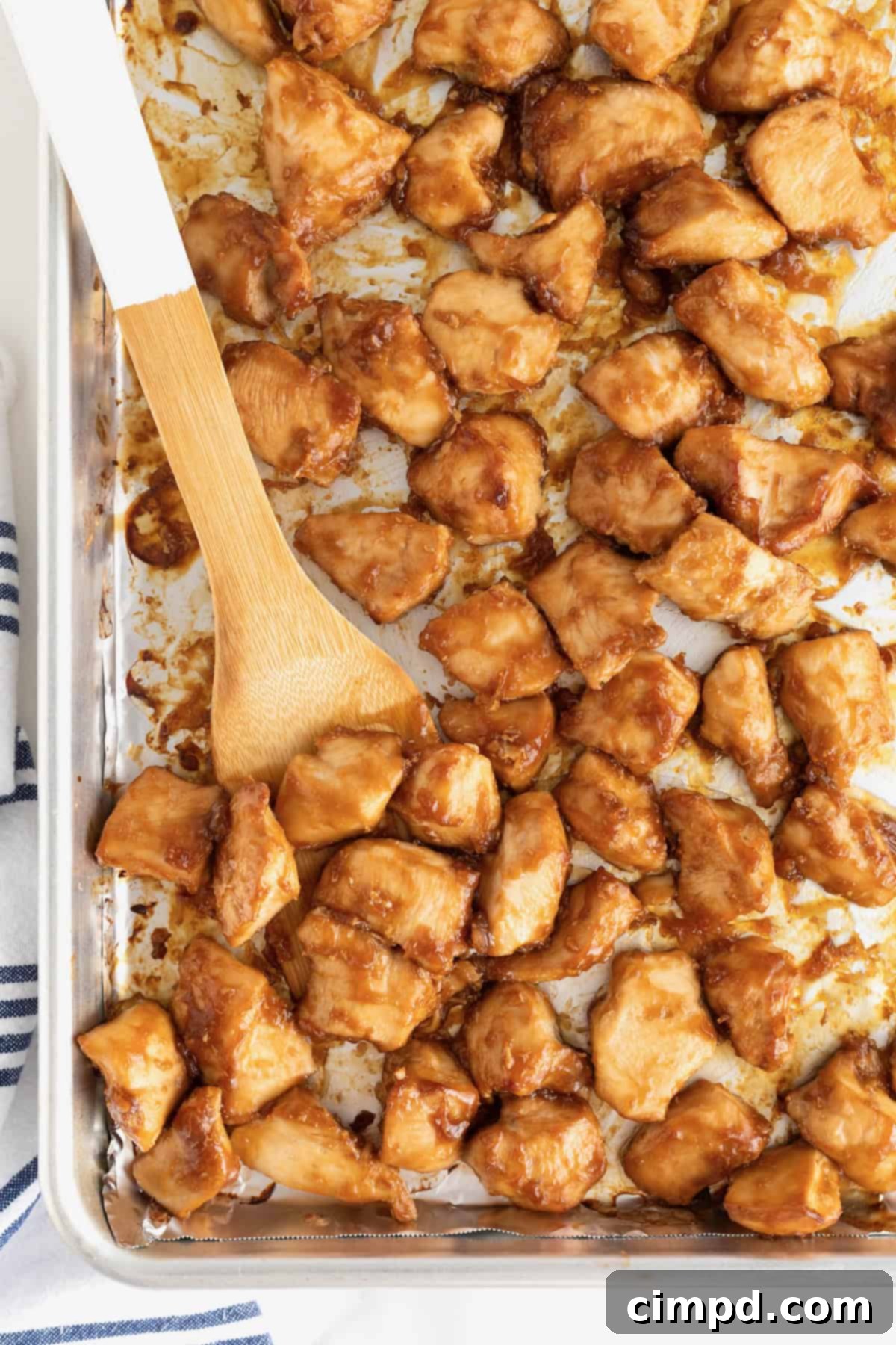 A full sheet pan of freshly baked orange chicken, generously coated in a rich, sticky glaze and ready to be served or stored, showcasing its tempting golden-brown perfection.