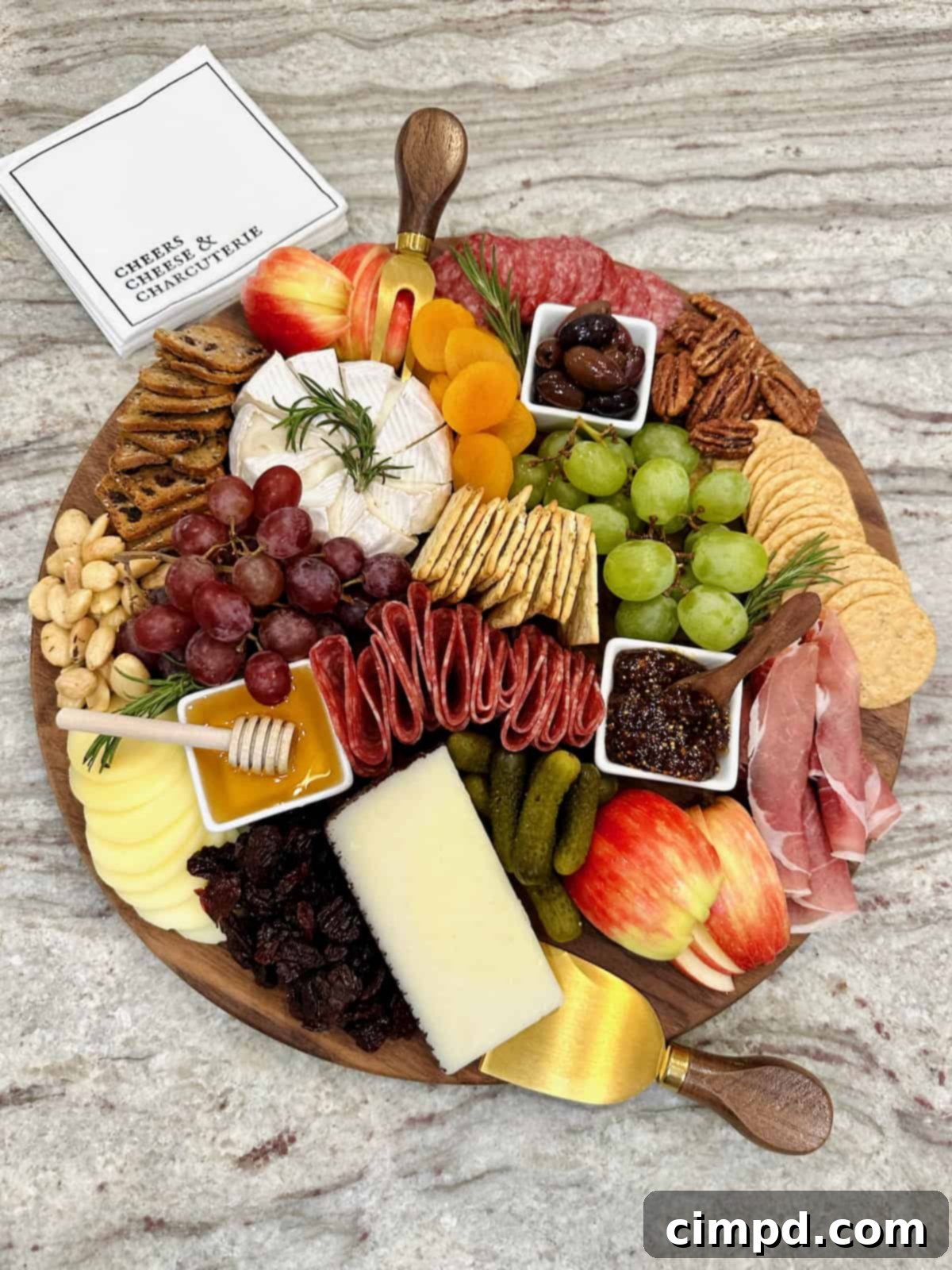 A beautifully arranged charcuterie board featuring a variety of cheeses, meats, fruits, nuts, and crackers, set on a gray marble counter, ready for effortless entertaining.