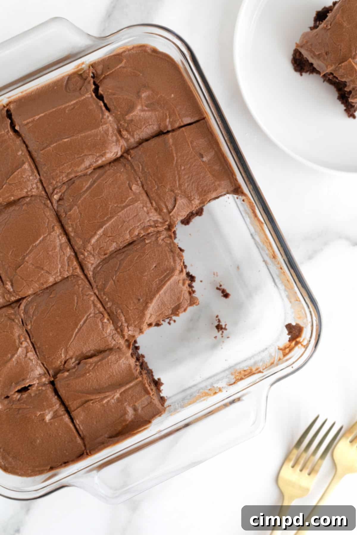 Mocha Velvet Brownies 4 A square glass baking dish of frosted brownies. The three corner brownies are missing.