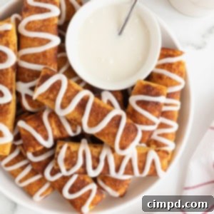 Gooey Cinnamon Fries 9 A large white serving plate of cinnamon roll sticks surrounding a bowl of white icing.