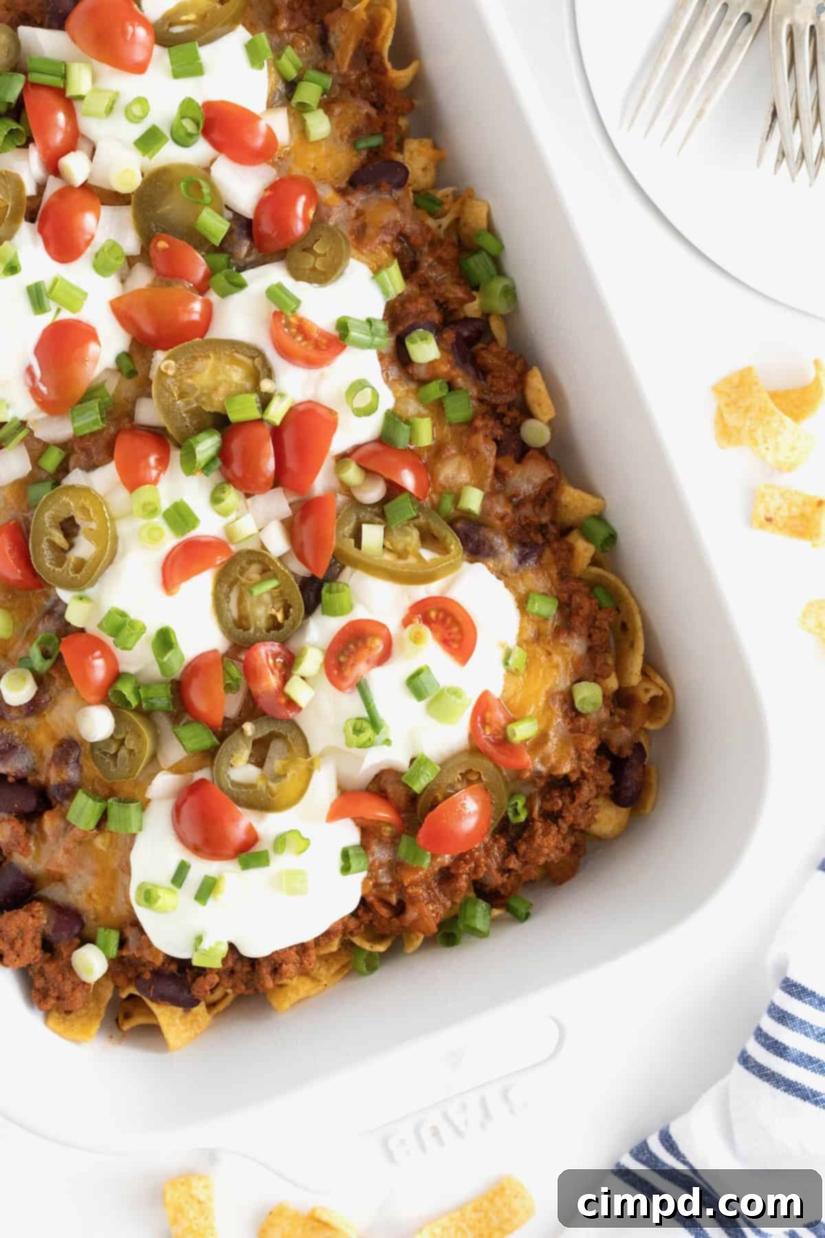 Loaded Frito Chili Bake 2 A white casserole dish of Frito Chili Pie casserole on a white marble counter, ready to be served.