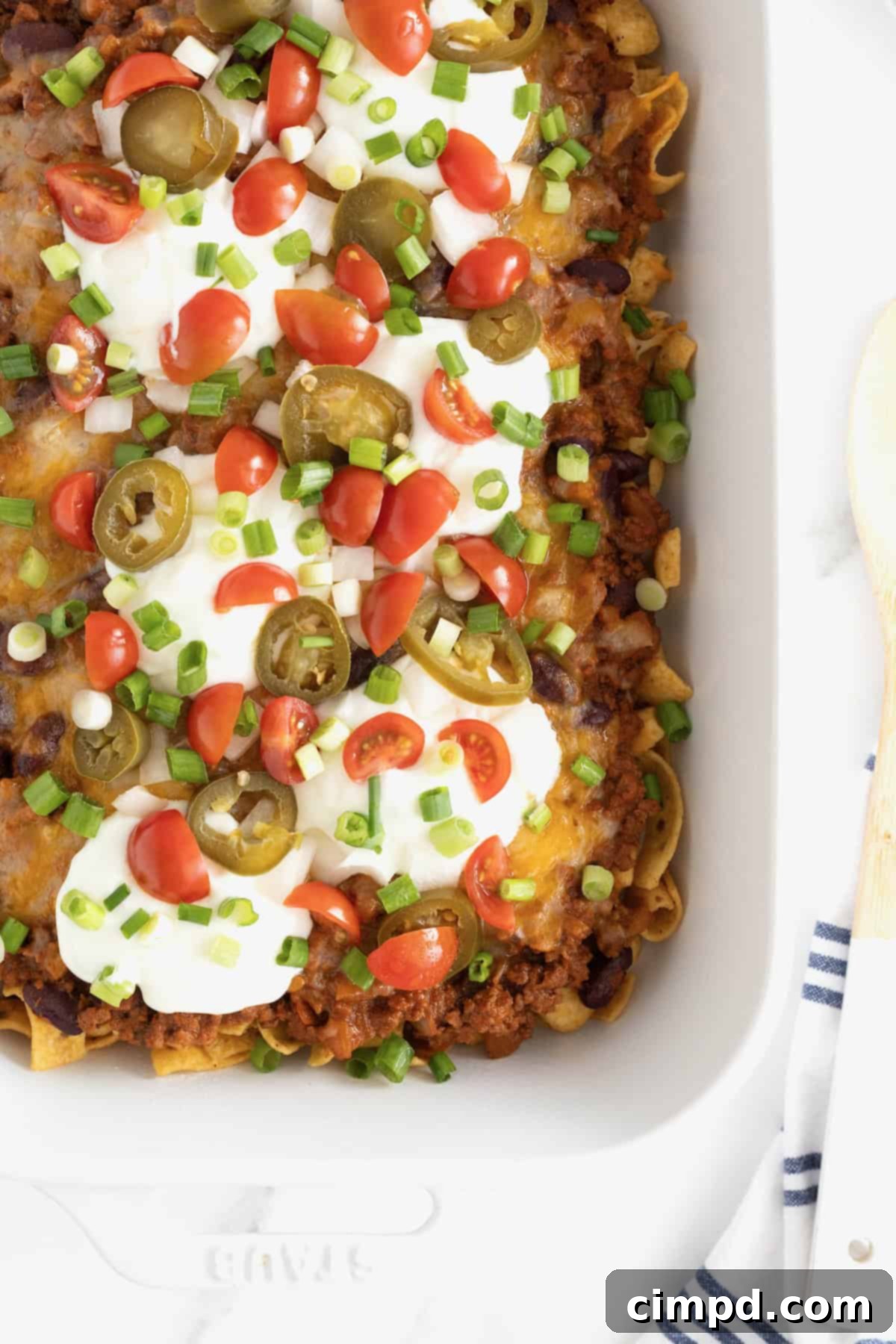 Loaded Frito Chili Bake 9 A white casserole dish of Frito Chili Pie casserole on a white marble counter, showcasing the complete dish.
