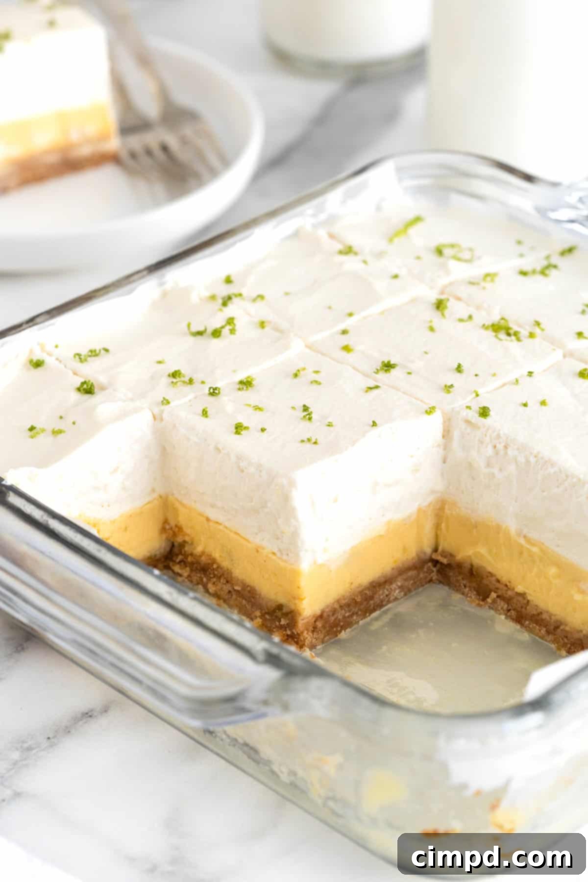 A square glass baking dish of key lime pie bars. Three squares are missing from the pan.