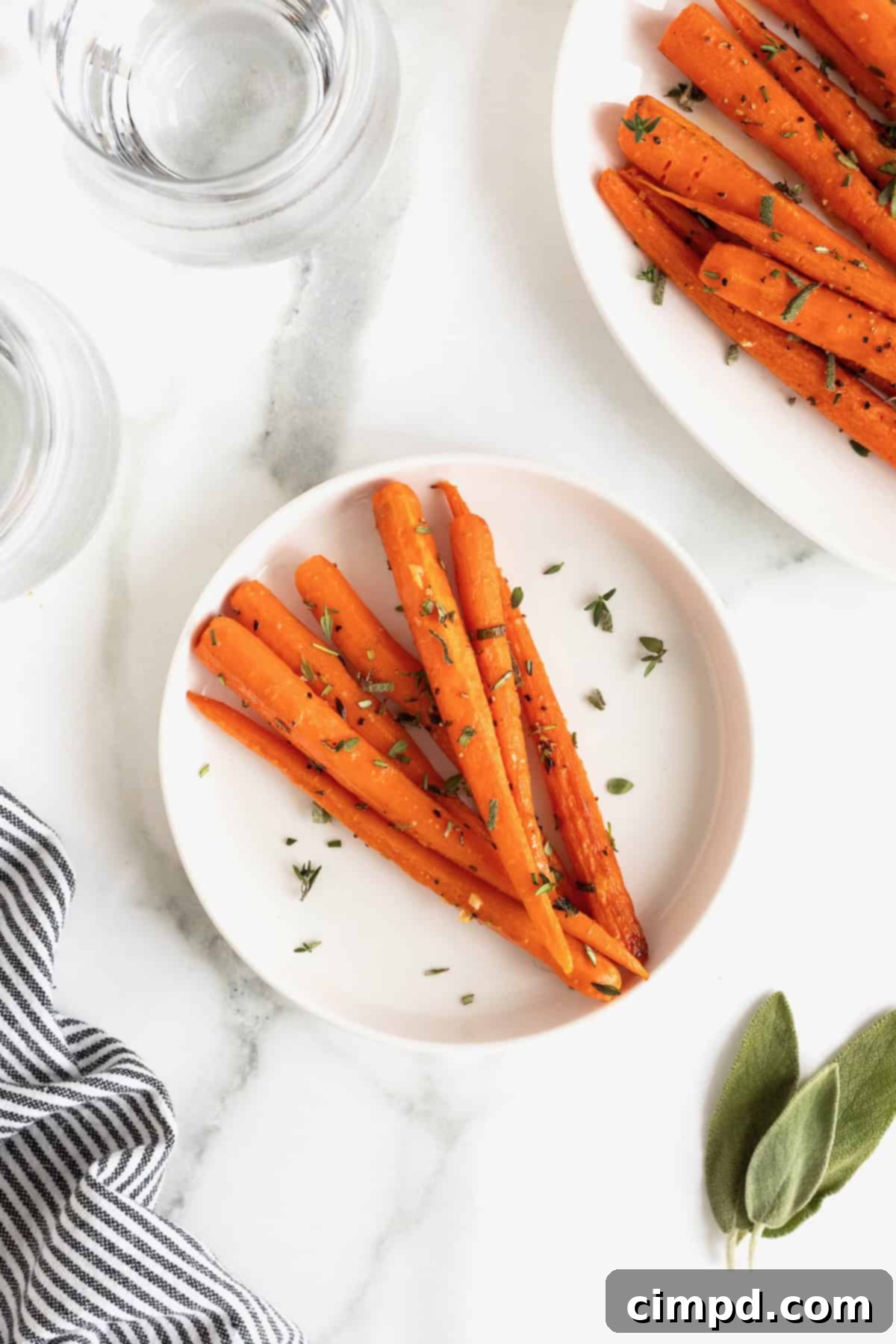 Golden Roasted Carrots 3 A small white plate showcasing perfectly oven roasted carrots, elegantly garnished with a sprinkle of fresh herbs, resting on a sophisticated white marble counter.
