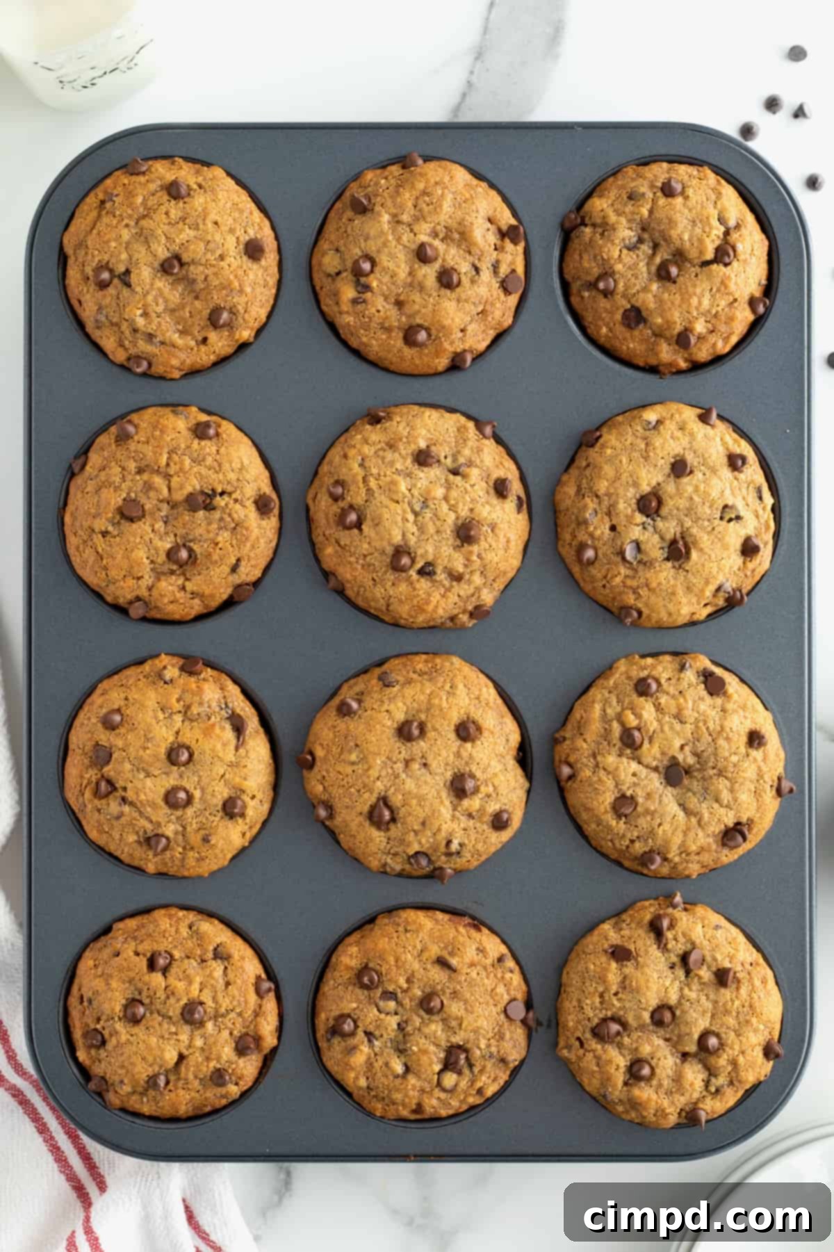 Freshly baked Whole Wheat Peanut Butter Banana Chocolate Chip Muffins cooling on a wire rack, showcasing their golden-brown tops and inviting texture, ready to be enjoyed.