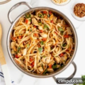 A stainless steel pot of chicken pad Thai on a white marble counter, serving as the main image for the recipe card.