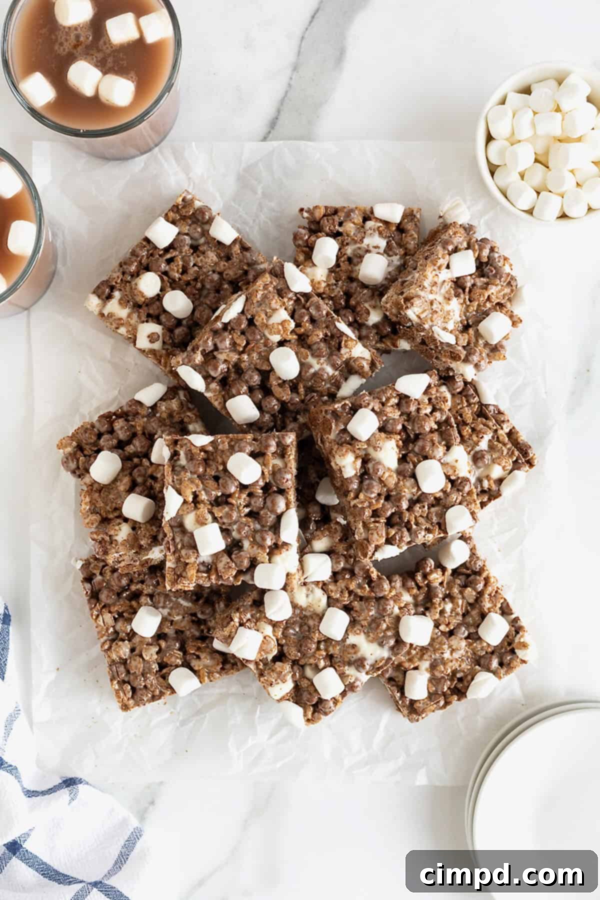 Cozy Hot Cocoa Krispies Squares 4 A pile of hot cocoa Krispies treats on a piece of parchment, ready for serving or packaging.
