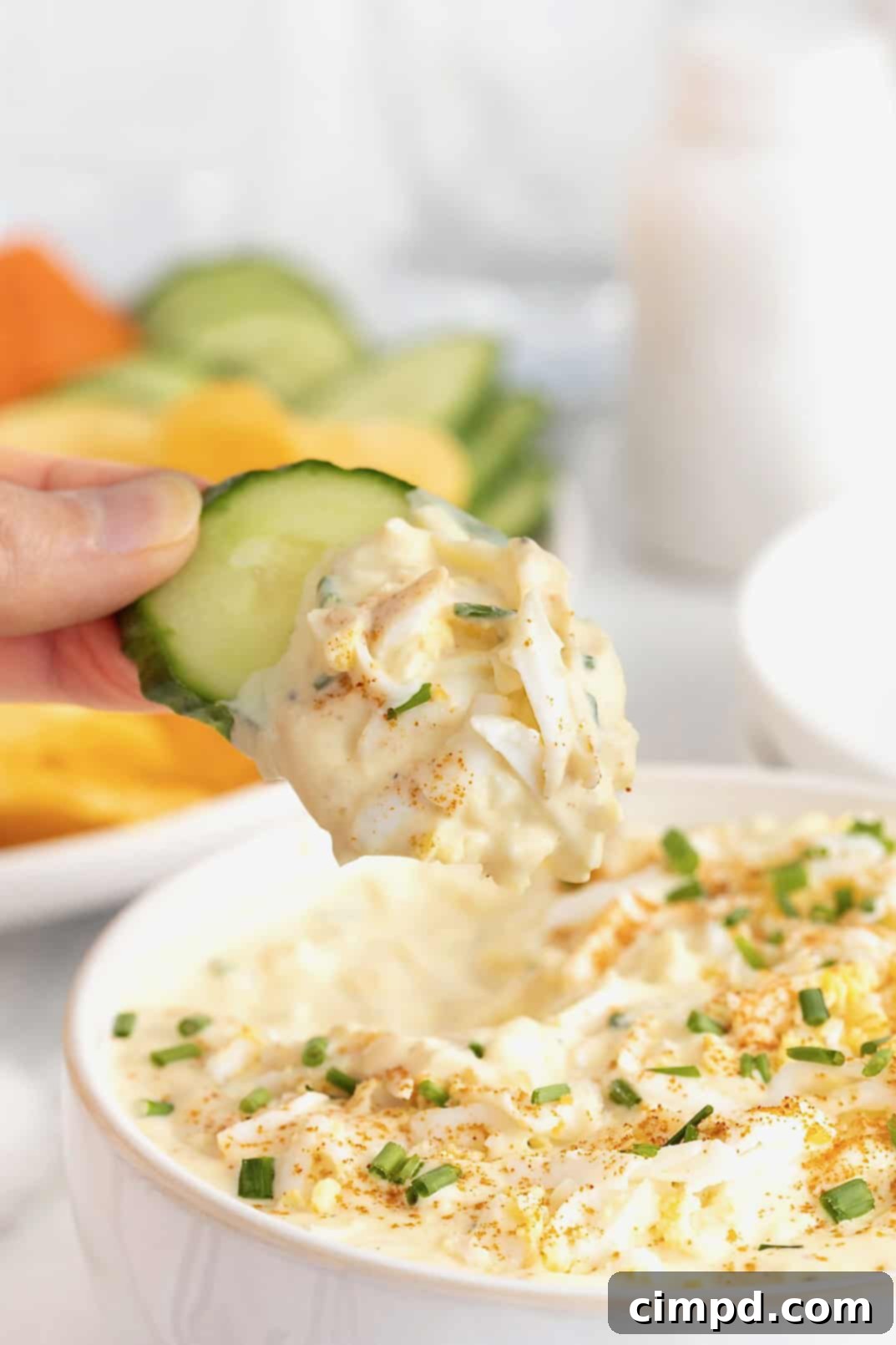A scoop of deviled egg dip on a cucumber slice.
