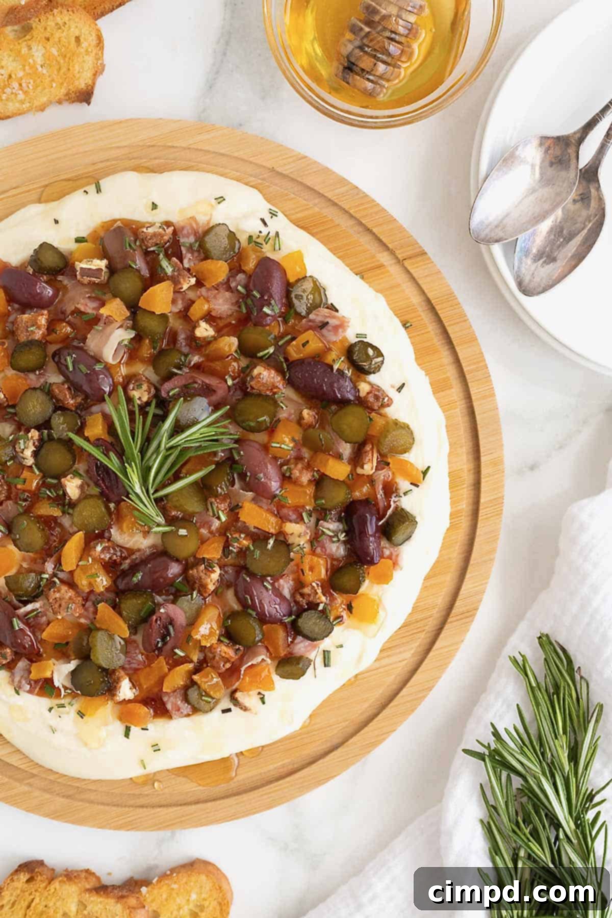 A round wooden food board with the Charcuterie Dip, ready for serving or storage, emphasizing its ease and appeal.