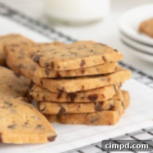 Crispy Chocolate Chip Snaps 13 A stack of six chocolate chip cookie crisps on a parchment lined cooling rack, showcasing their delicate crispness.