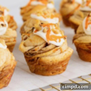 Flaky Spiced Carrot Cruffins 15 Nine carrot cake cruffins topped with cream cheese frosting, chopped walnuts and shredded carrots on a parchment lined cooling rack.