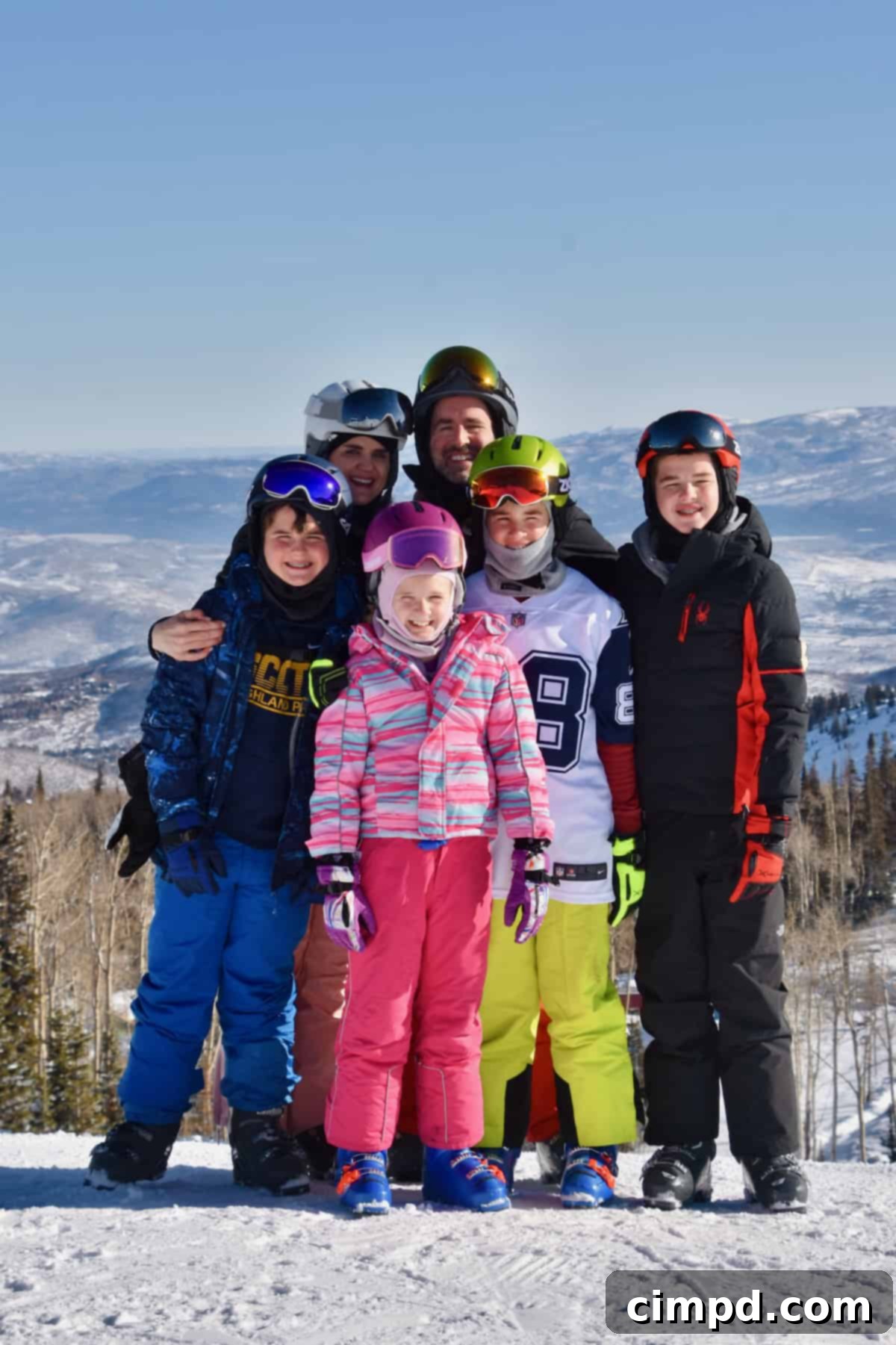 The Brown family in colorful ski gear with Deer Valley in the background, enjoying a perfect spring day.