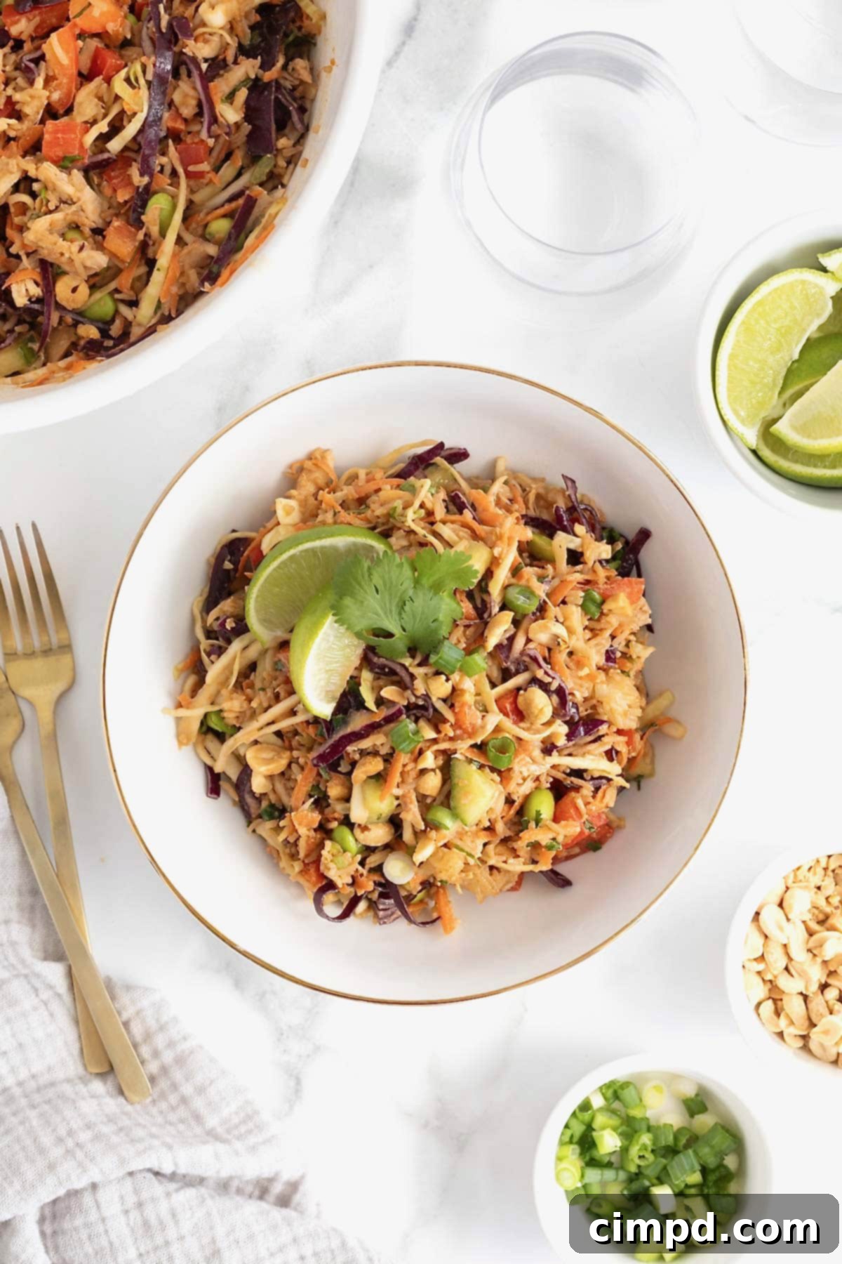 A white bowl filled with crispy rice chicken salad topped with a lime wedge.