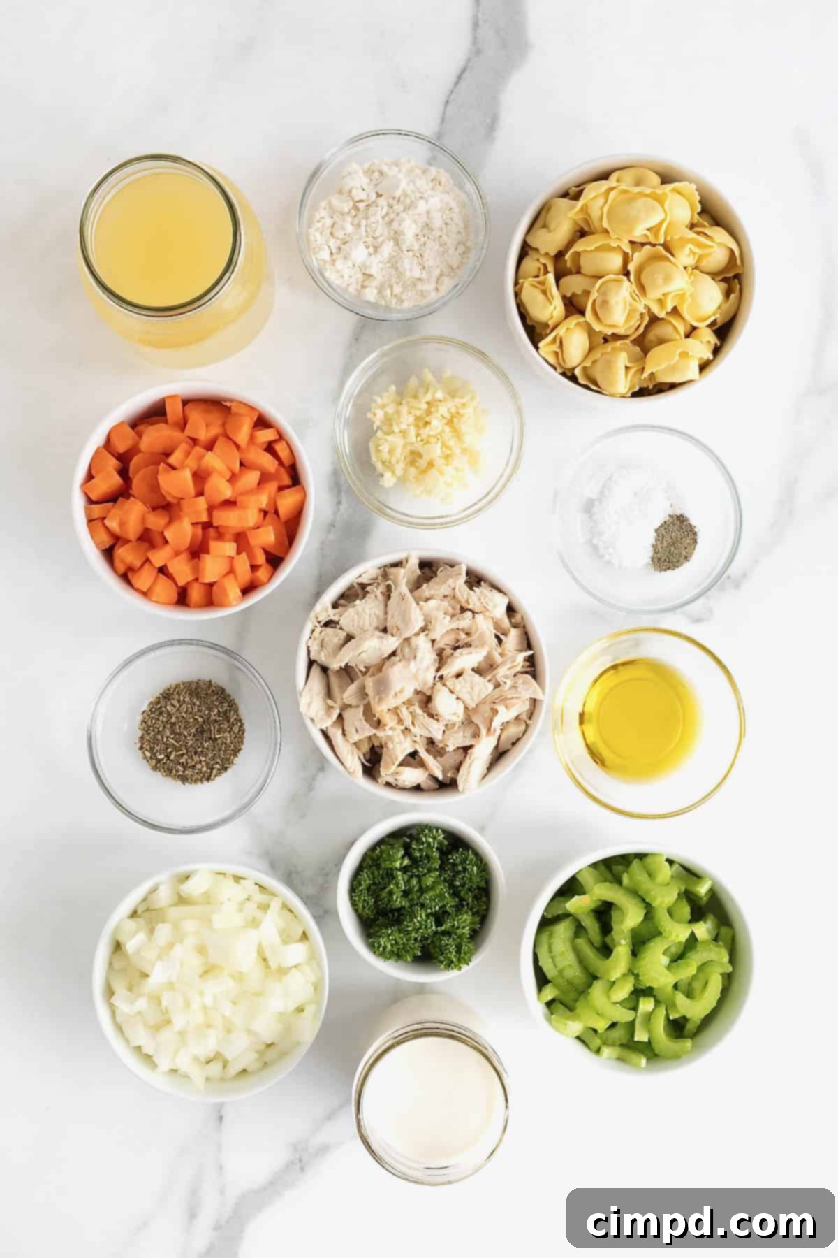 Homestyle Creamy Chicken Tortellini Soup 5 Ingredients to make creamy chicken tortellini soup in small glass dishes on a white marble counter.