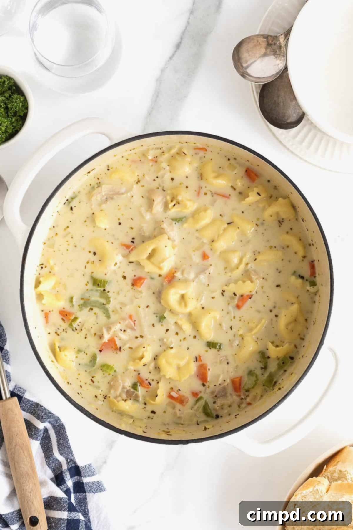 Homestyle Creamy Chicken Tortellini Soup 8 A white Dutch oven of creamy soup with carrots, celery and tortellini pasta.