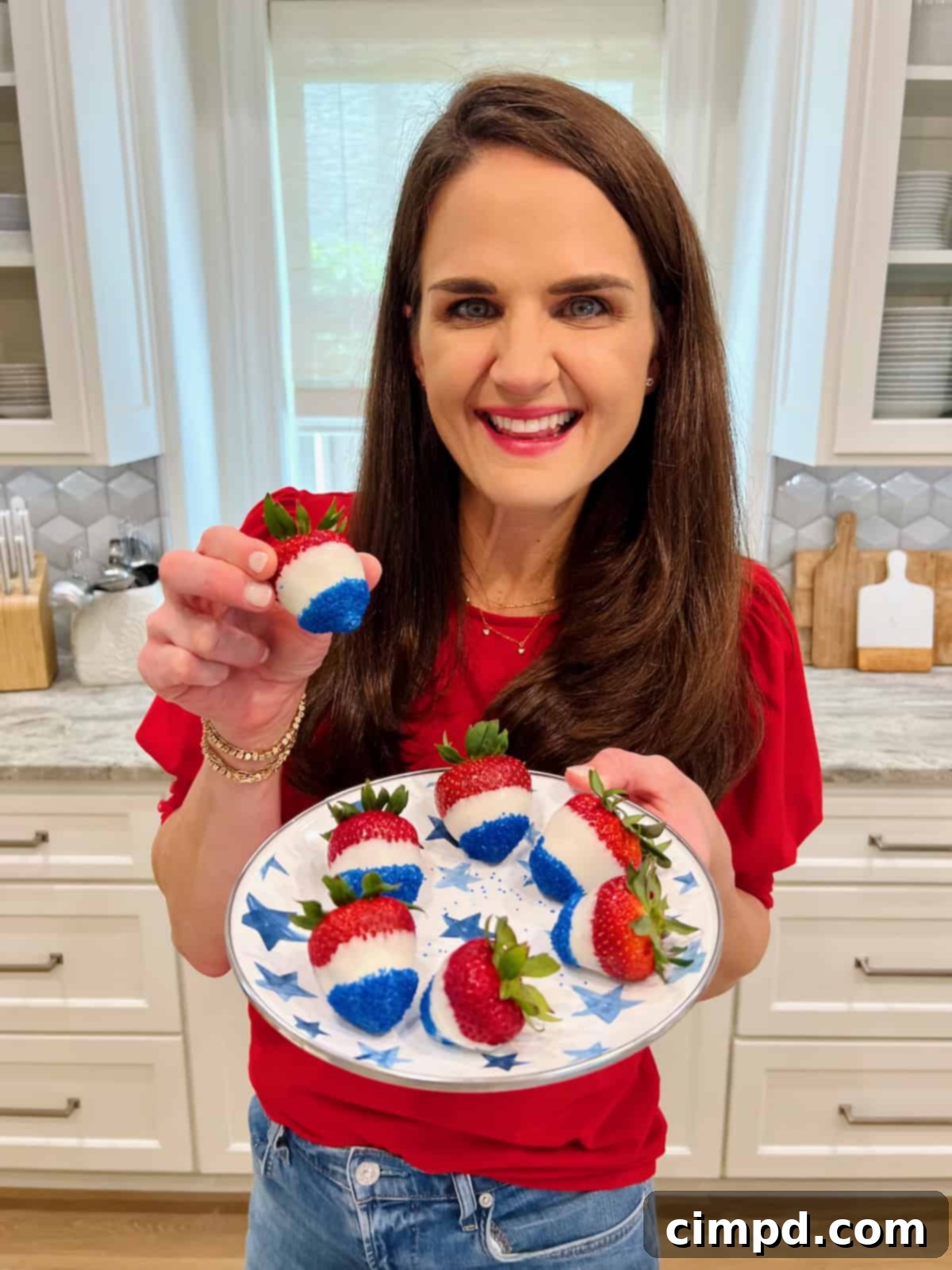 Simple Star-Spangled Bites 7 Maegan Brown holds a perfectly crafted red, white, and blue dipped strawberry, showcasing the elegance of this simple patriotic treat.