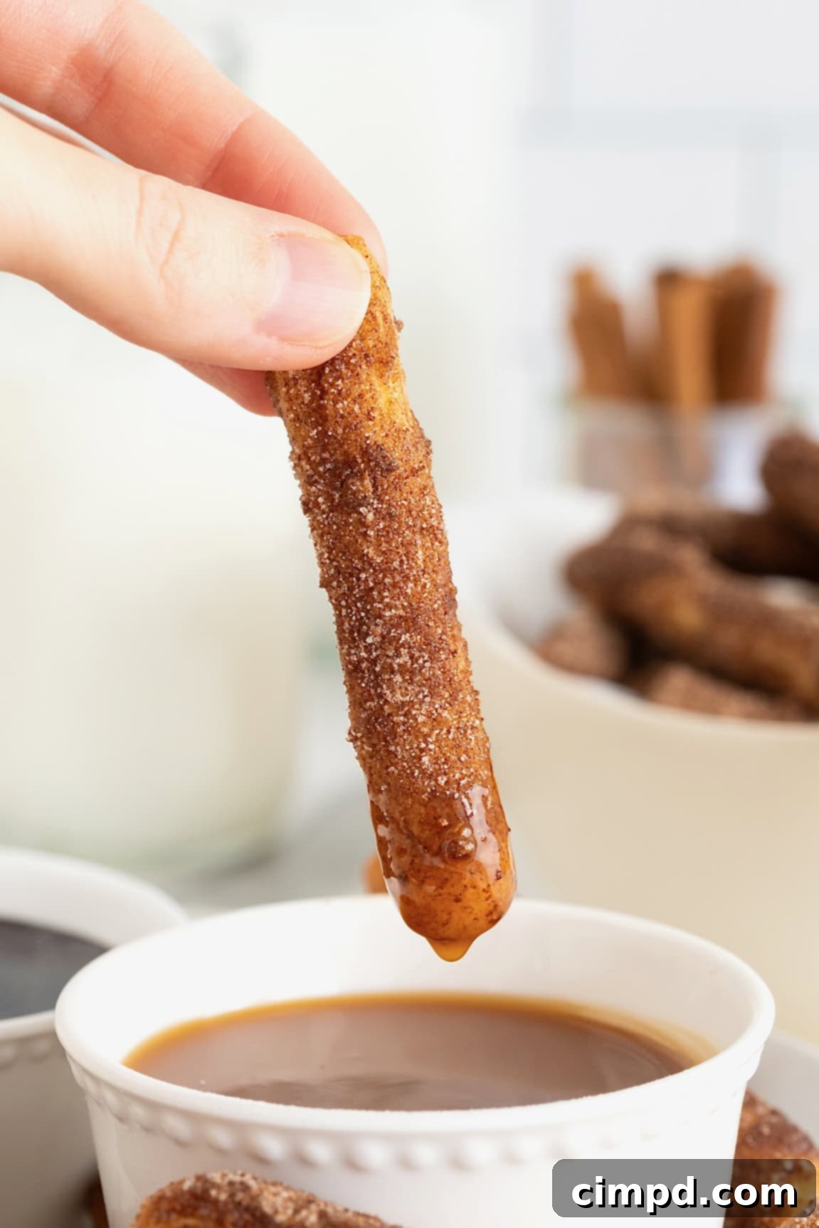 Guilt-Free Baked Churros 3 A churro being dipped into caramel sauce.
