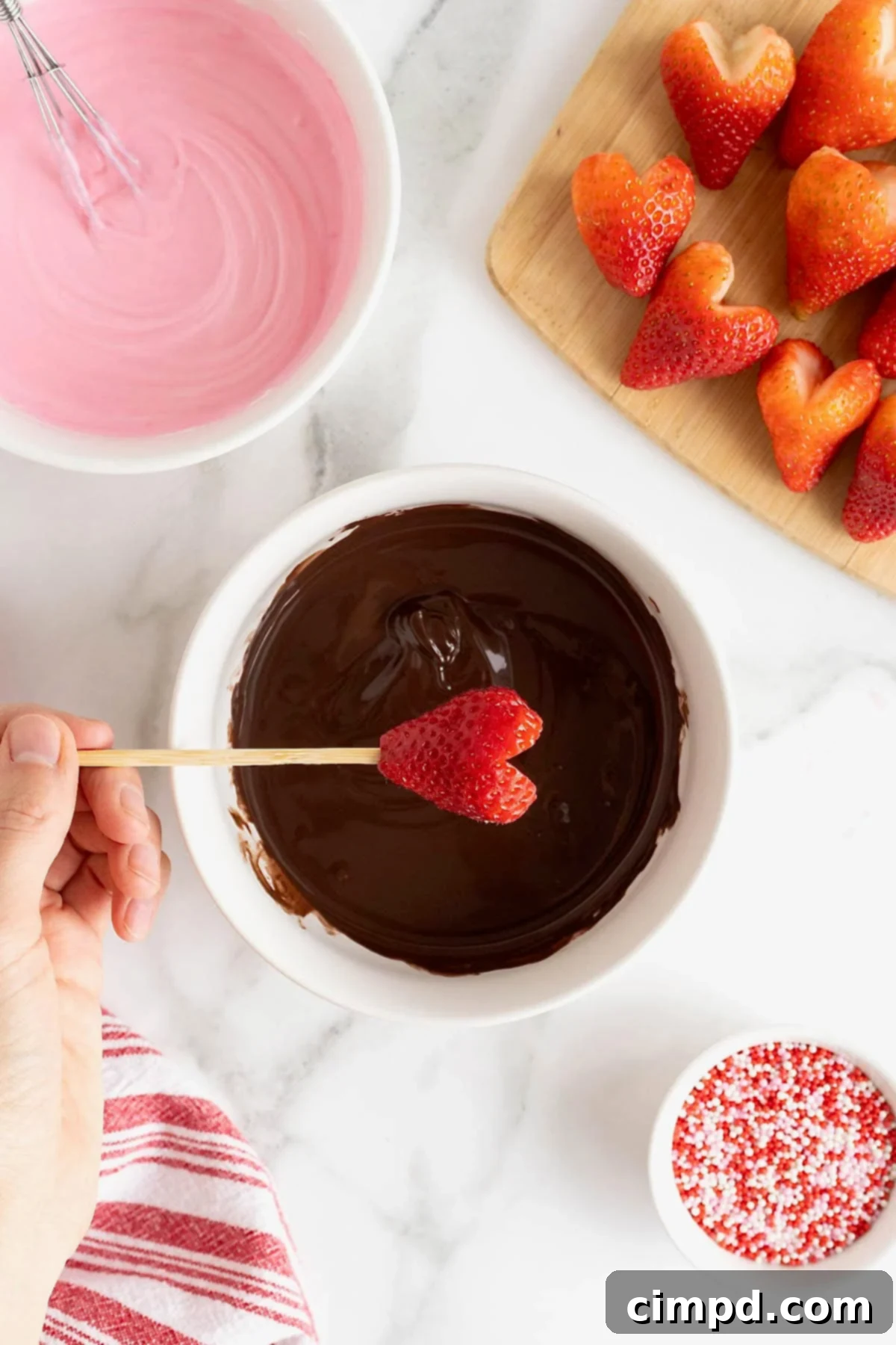 Sweetheart Chocolate Strawberries 8 A heart-shaped strawberry being carefully submerged into a pool of glistening melted chocolate, capturing the moment of transformation.