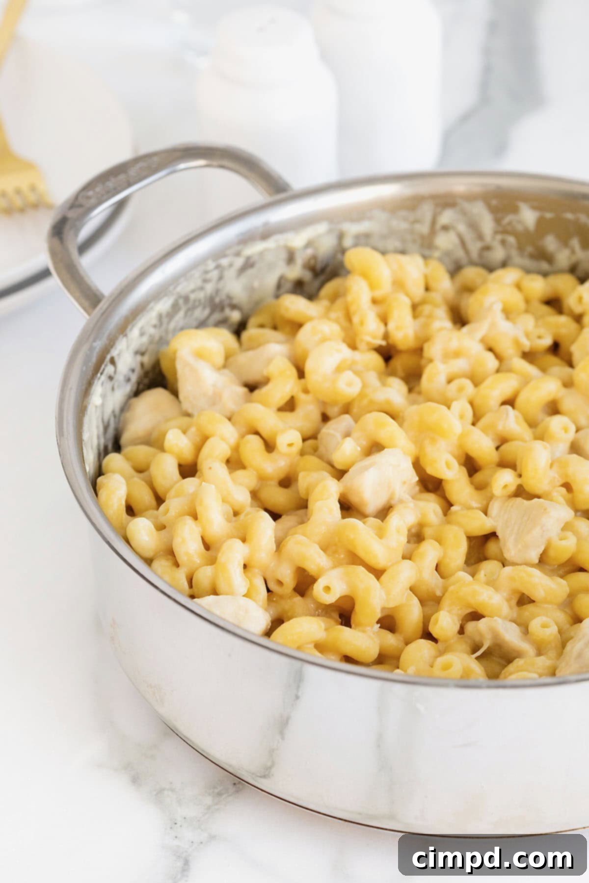 A stainless steel pot of chicken Alfredo with cavatappi pasta.