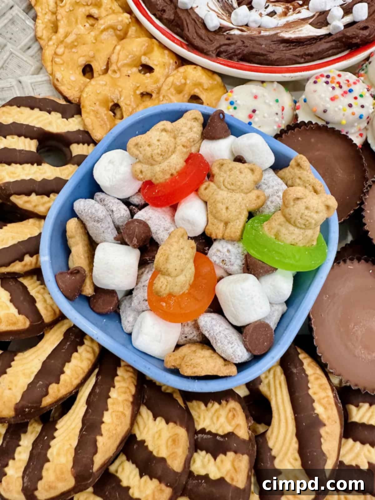 Kids Summer Smores Fun Board 5 A charming light blue bowl filled with a delightful S'mores snack mix, featuring playful Teddy Graham swimmers, sits invitingly on a summer s'mores board.