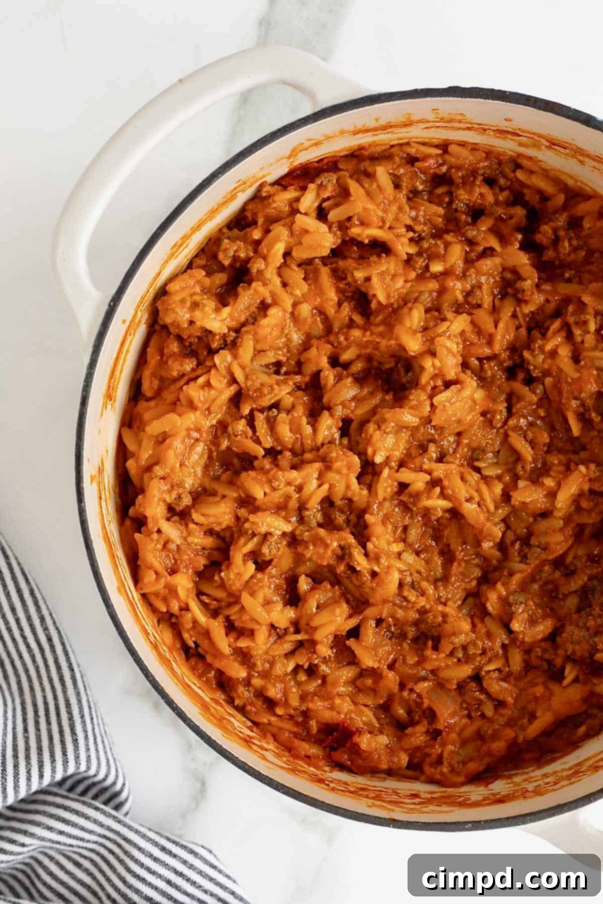 One-Pot Sloppy Joe Orzo 9 A white Dutch oven of sloppy Joe orzo on a white marble counter.
