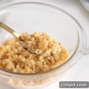 Homemade Streusel Simplified 12 A spoonful of streusel being lifted from a glass bowl, showcasing its delicious texture.