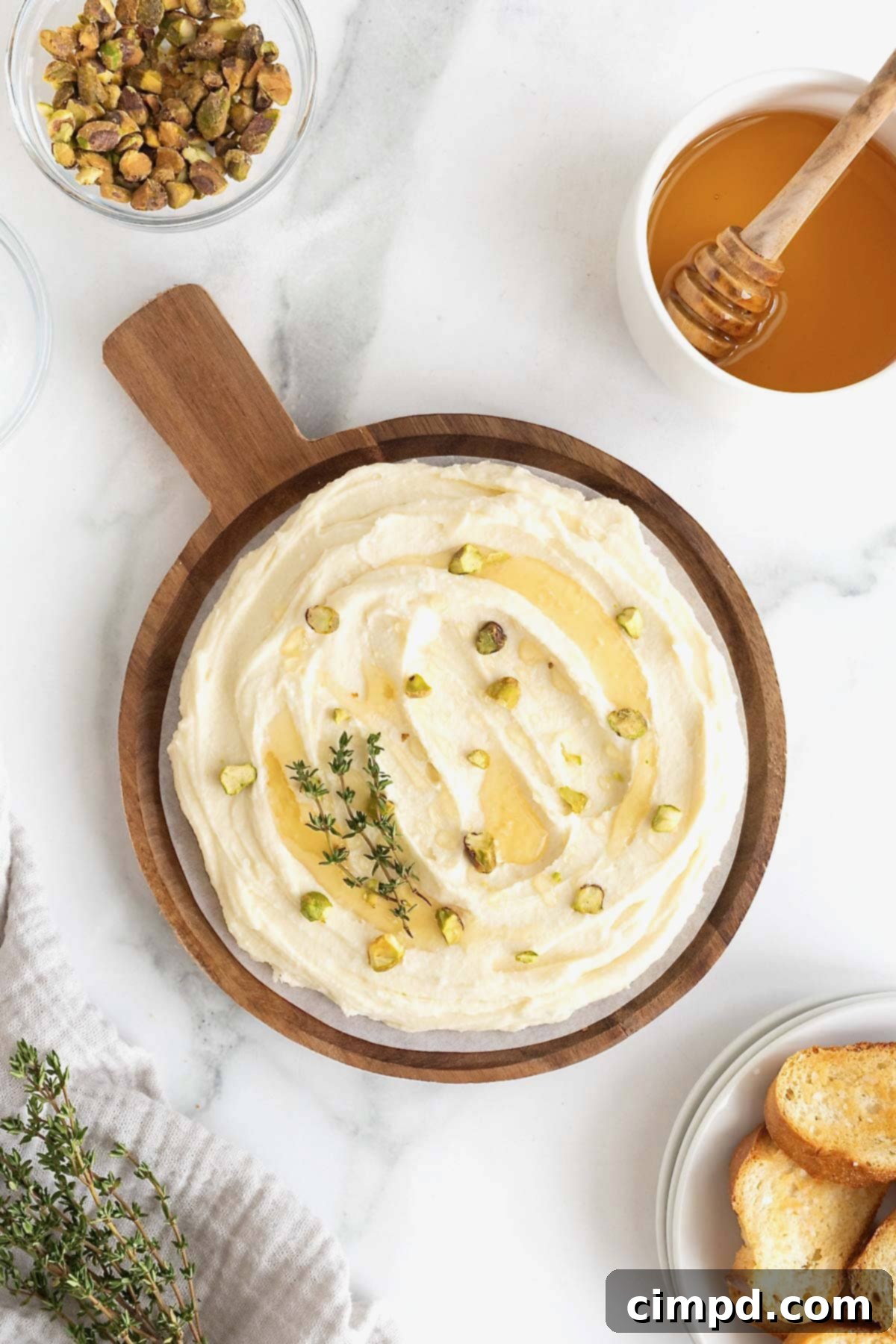 Creamy Whipped Brie 11 A visually appealing sweet whipped brie dish, generously drizzled with honey and sprinkled with vibrant chopped pistachios, showcasing a delicious combination of textures and flavors.