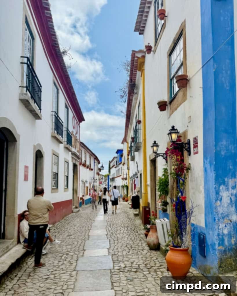 A couple exploring the charming, hilly streets of Lisbon, Portugal, with historic buildings.
