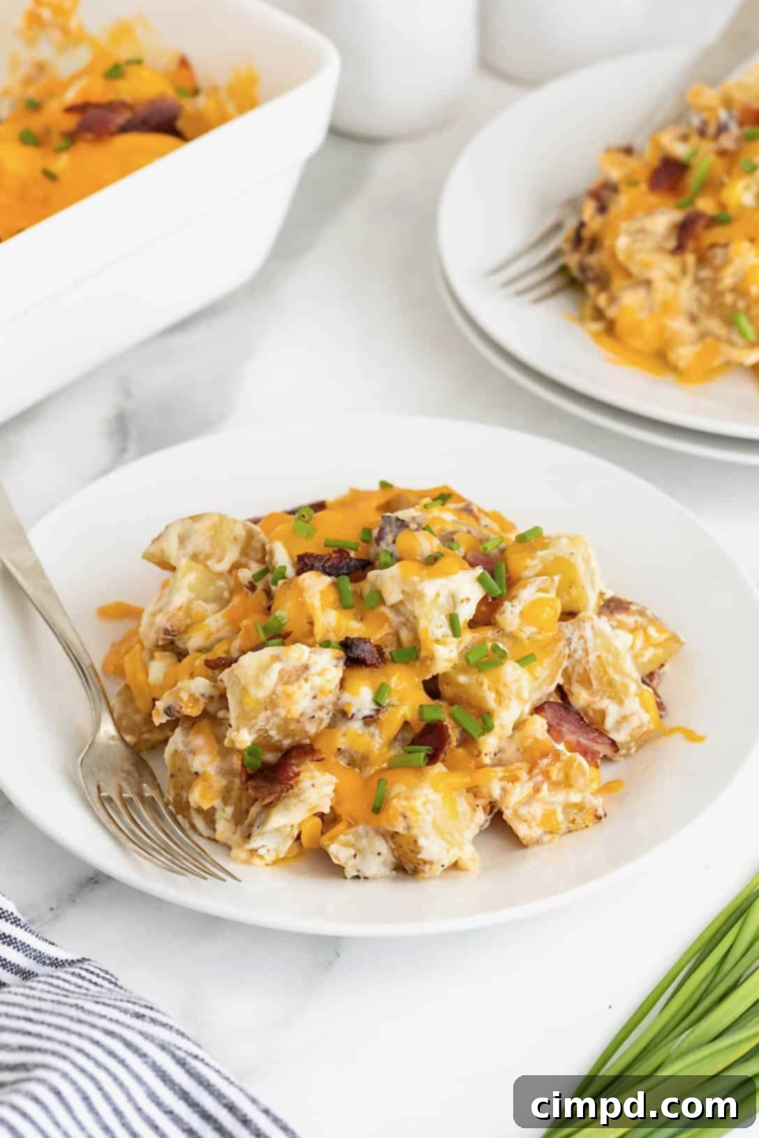 A small white plate of twice baked potato casserole on a white marble counter.