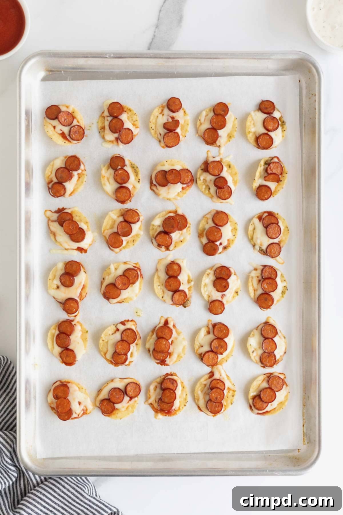Pizza taco bites on a parchment lined baking sheet.