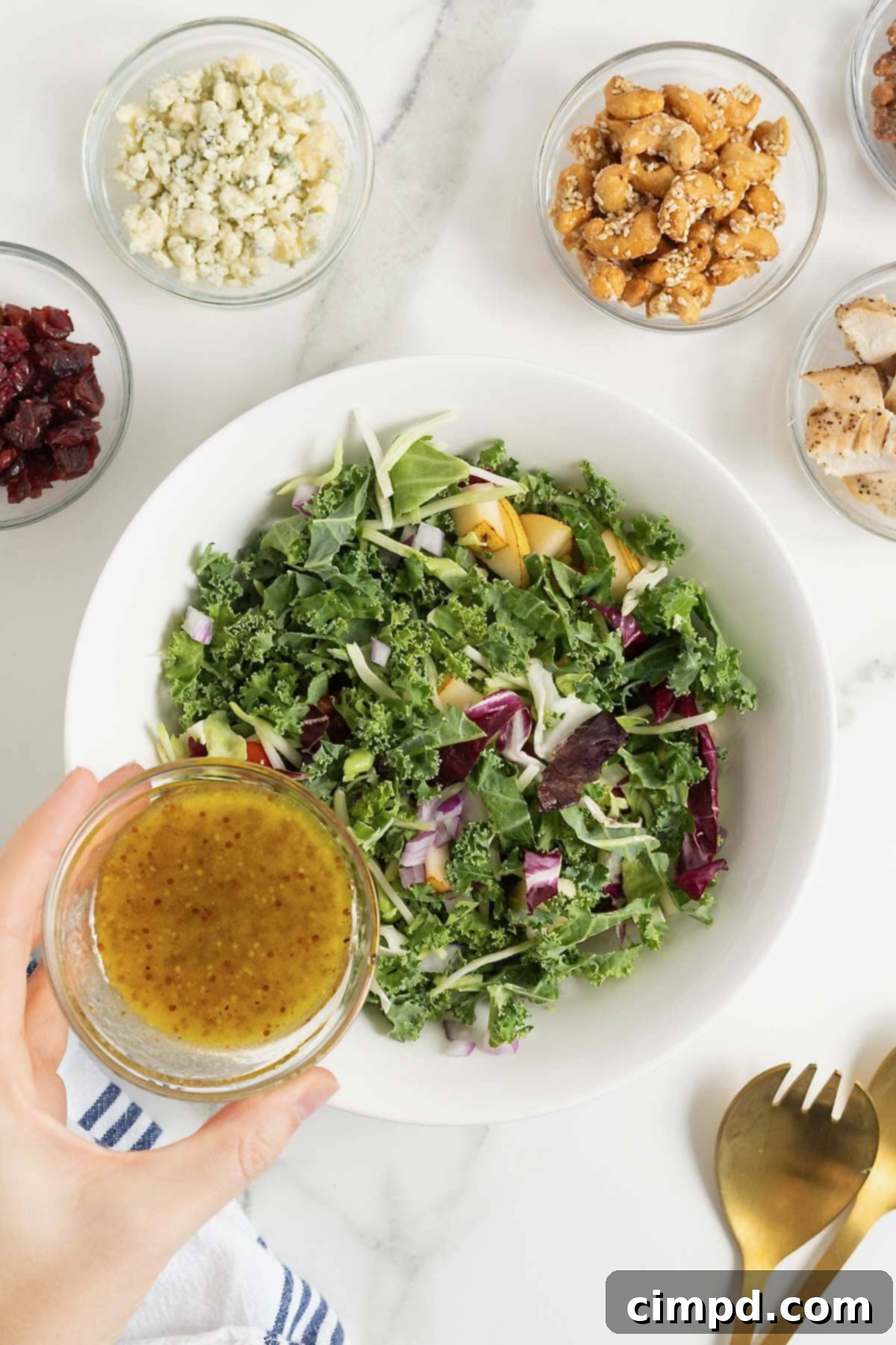 Sparkling Vinaigrette 9 Champagne vinaigrette being poured from a small glass carafe onto a green salad.