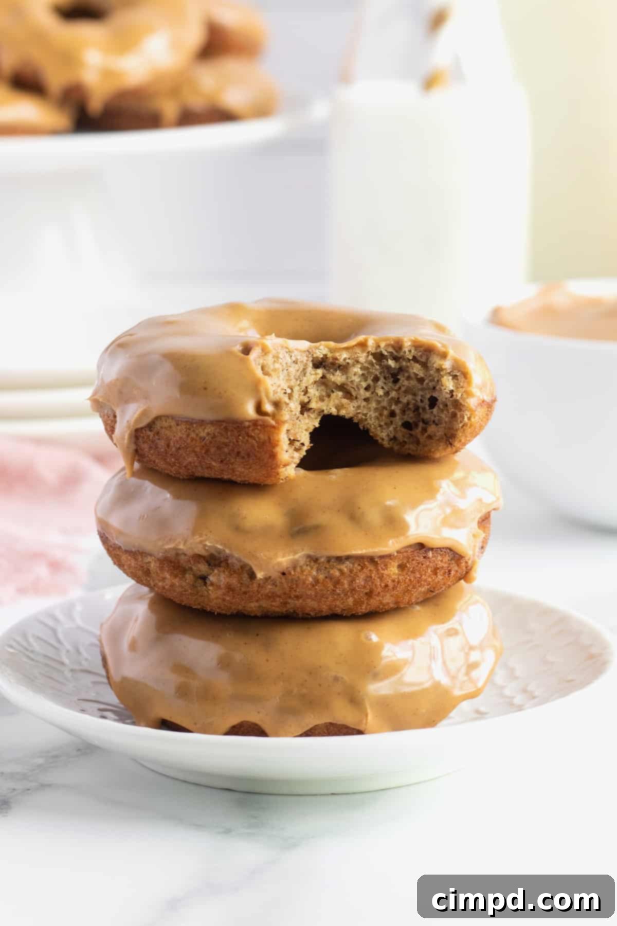 Stack of Whole Wheat Baked Banana Donuts with Peanut Butter Glaze, ready to be enjoyed as a wholesome breakfast or snack