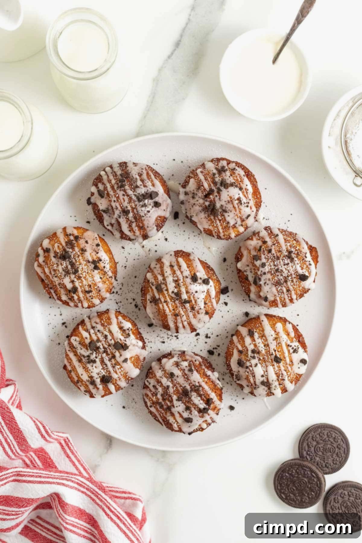 Cinnamon Bun Oreo Fritters 10 A white rimmed plate filled with 8 cinnamon roll fried Oreos.