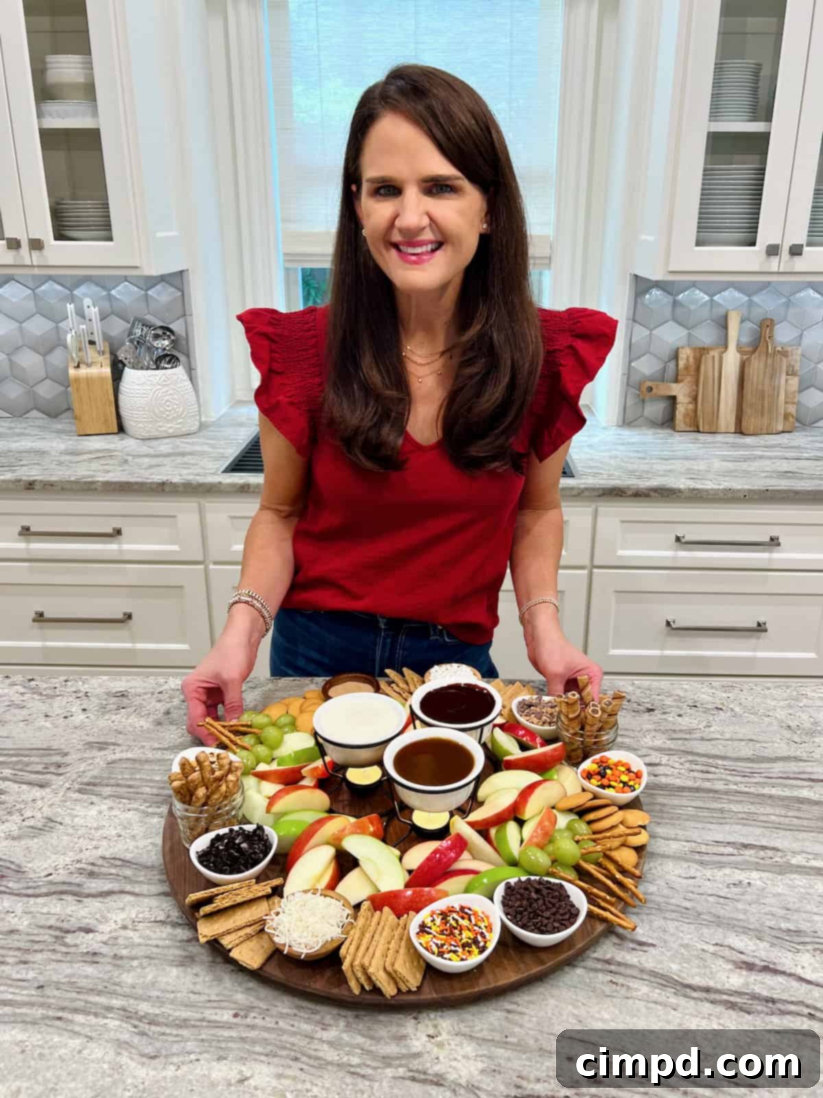 Maegan Brown showing an apple dipping board with various dips and dippers.