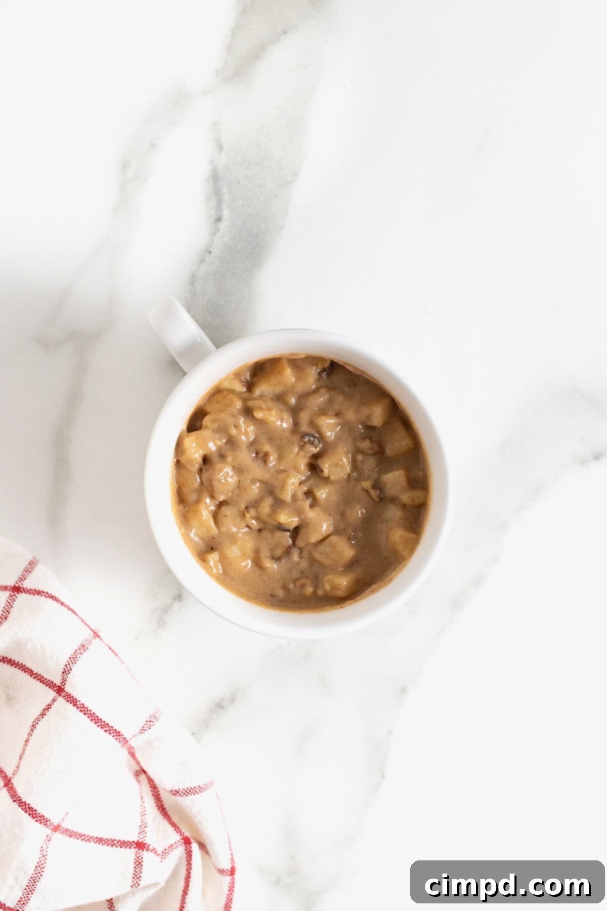 Spiced Apple Mug Delight 9 The apple cake batter neatly smoothed into a white mug, sitting on a white marble countertop, poised for its quick microwave journey.