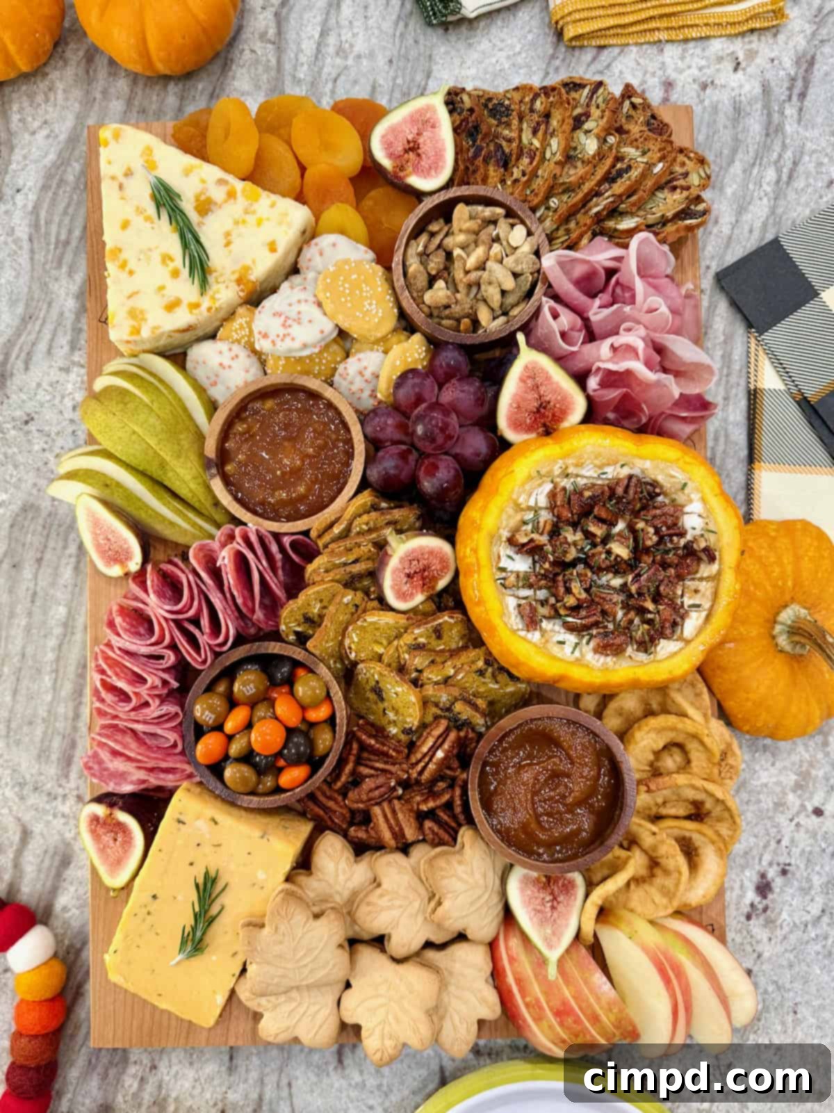 Autumn's Canvas: A Community Art Project 2 A rectangular wooden food board filled with autumnal snacks like cheese, salami, sliced pear, and a savory pumpkin dip.