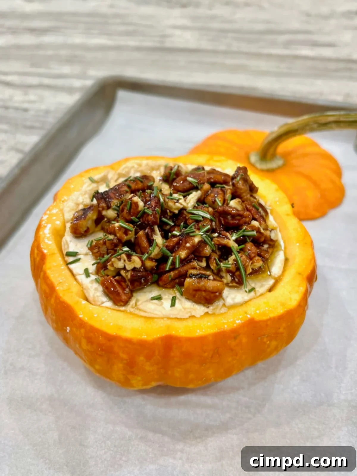Autumn's Canvas: A Community Art Project 4 Pumpkin baked brie baking on a parchment-lined baking sheet, golden and inviting.