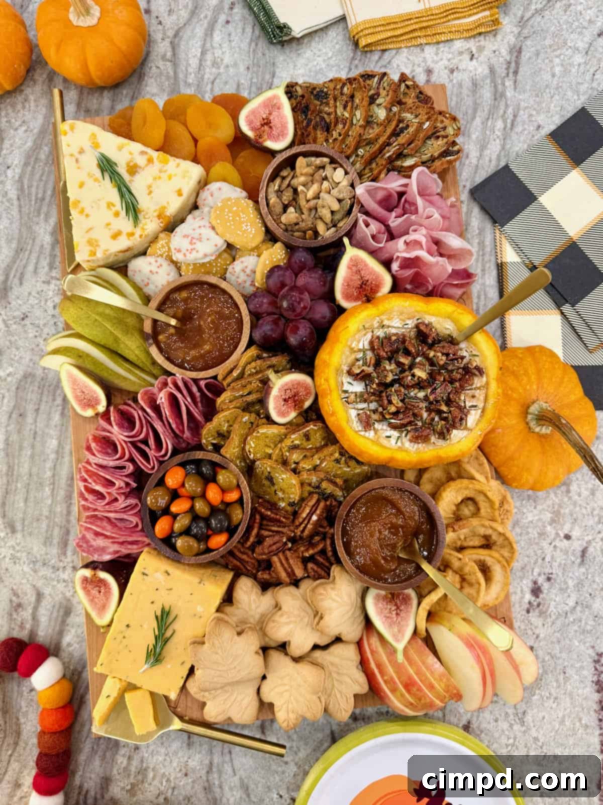 Autumn's Canvas: A Community Art Project 5 A beautifully arranged rectangular wooden food board overflowing with autumnal snacks, including various cheeses, cured meats, fresh and dried fruits, and the star pumpkin baked brie dip.