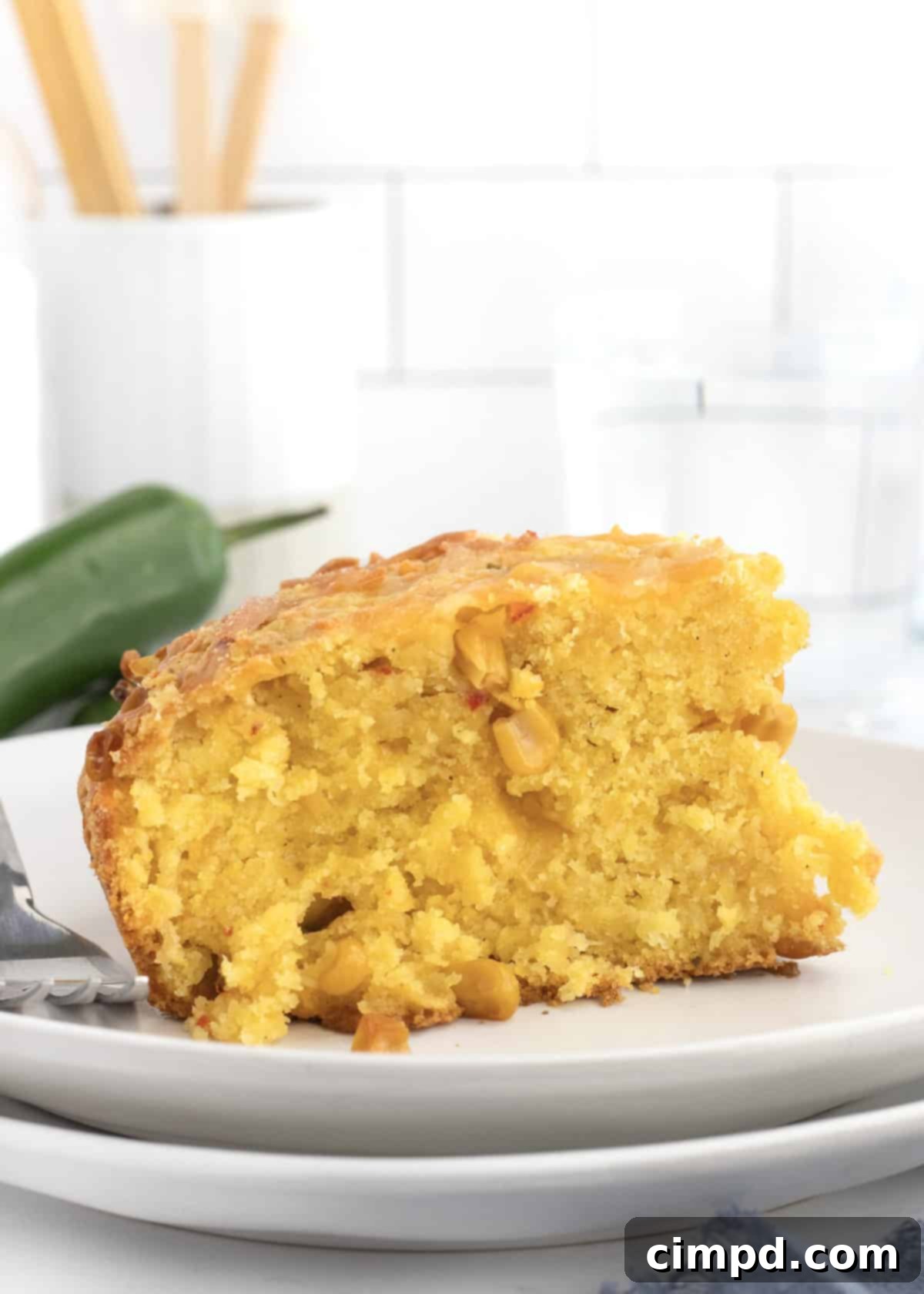 Close-up of a slice of Cheesy Corn Cornbread, showing the moist interior and visible corn kernels.